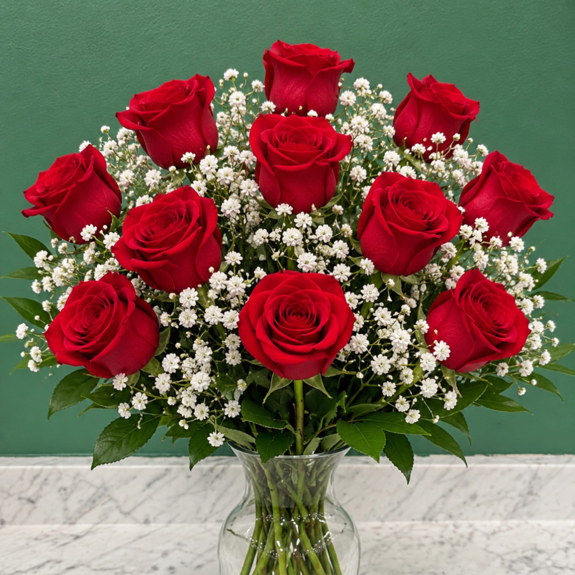 Red roses and white baby's breath in a clear glass vase