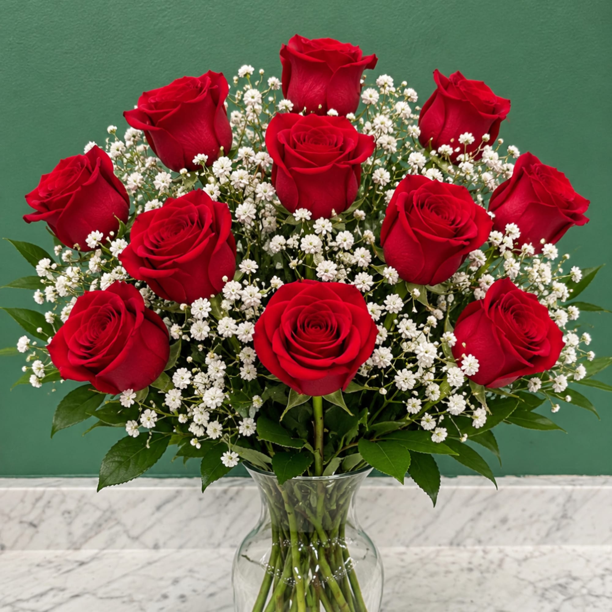 Red roses and white baby's breath in a clear glass vase