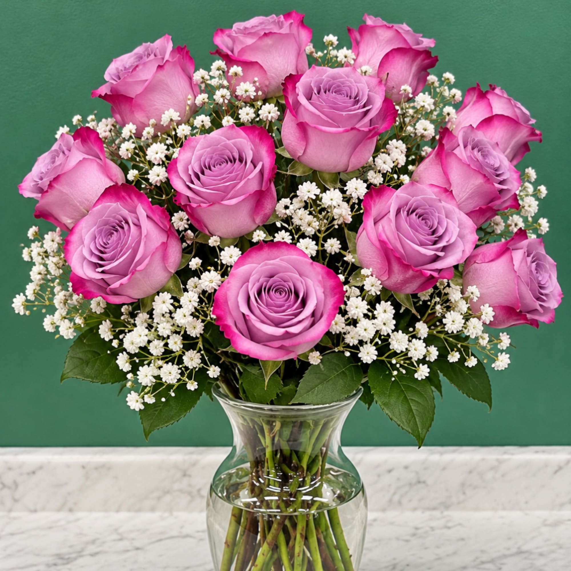Pink roses and white baby's breath in a clear glass vase