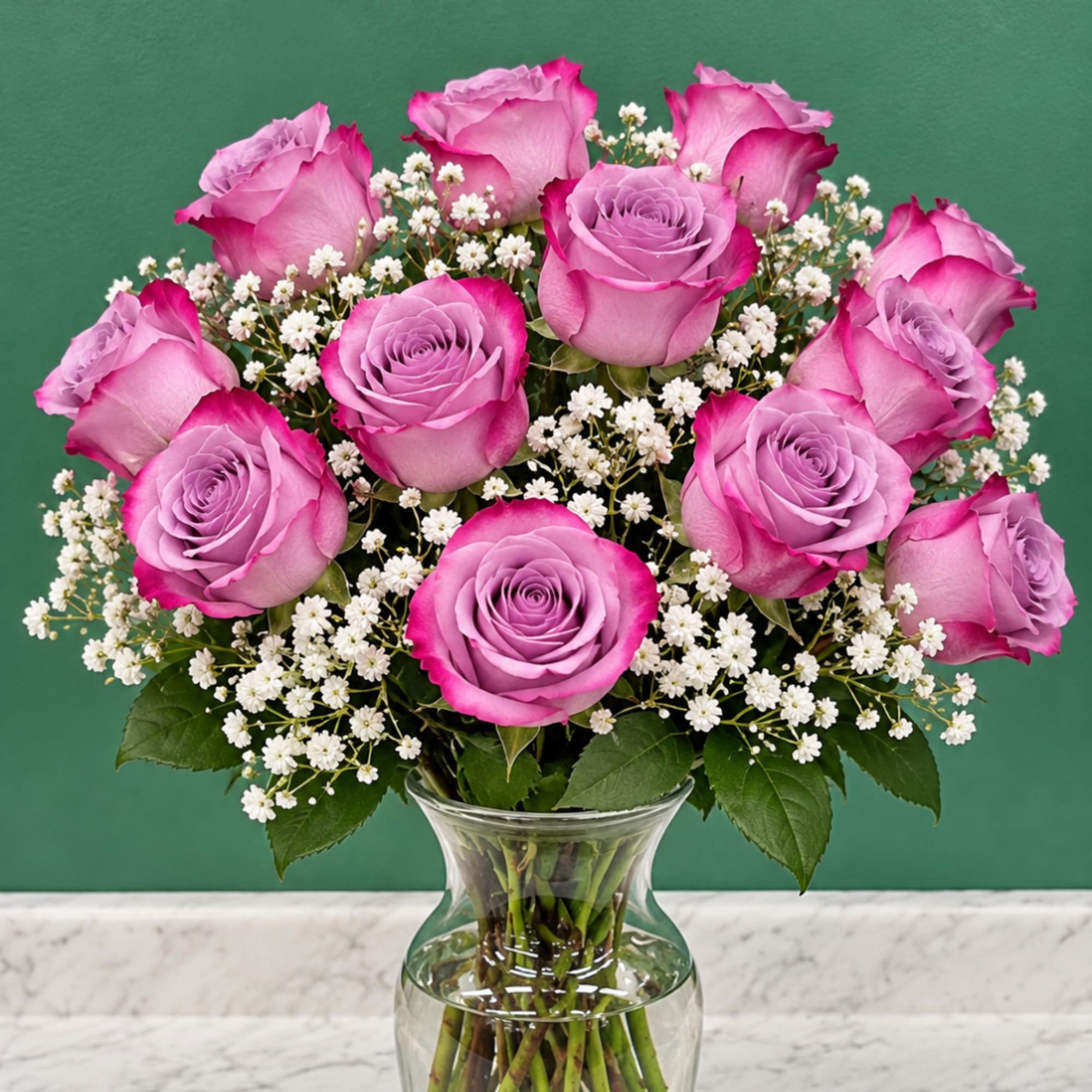 Pink roses with white baby's breath in a clear glass vase