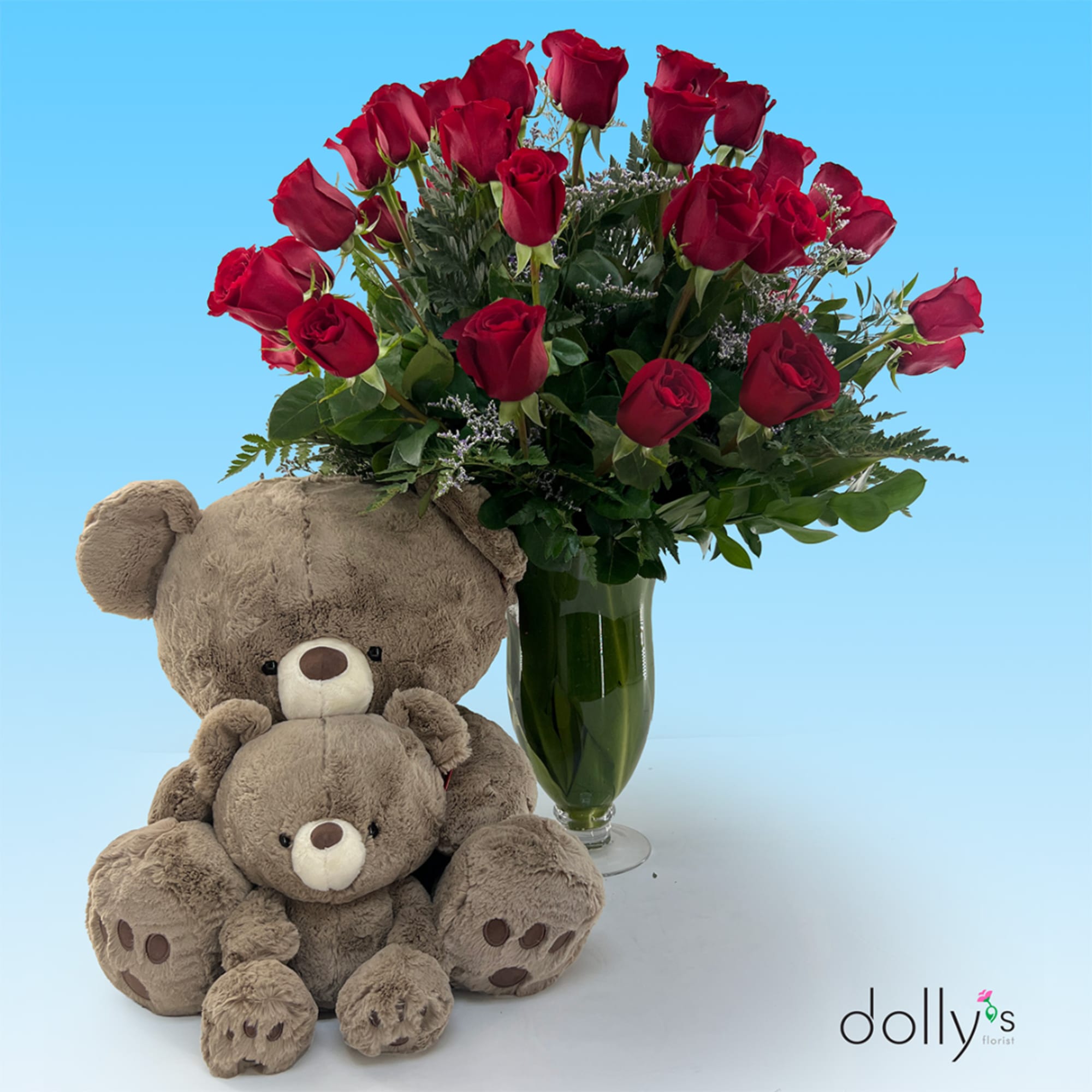 Red roses in a glass vase with two teddy bears