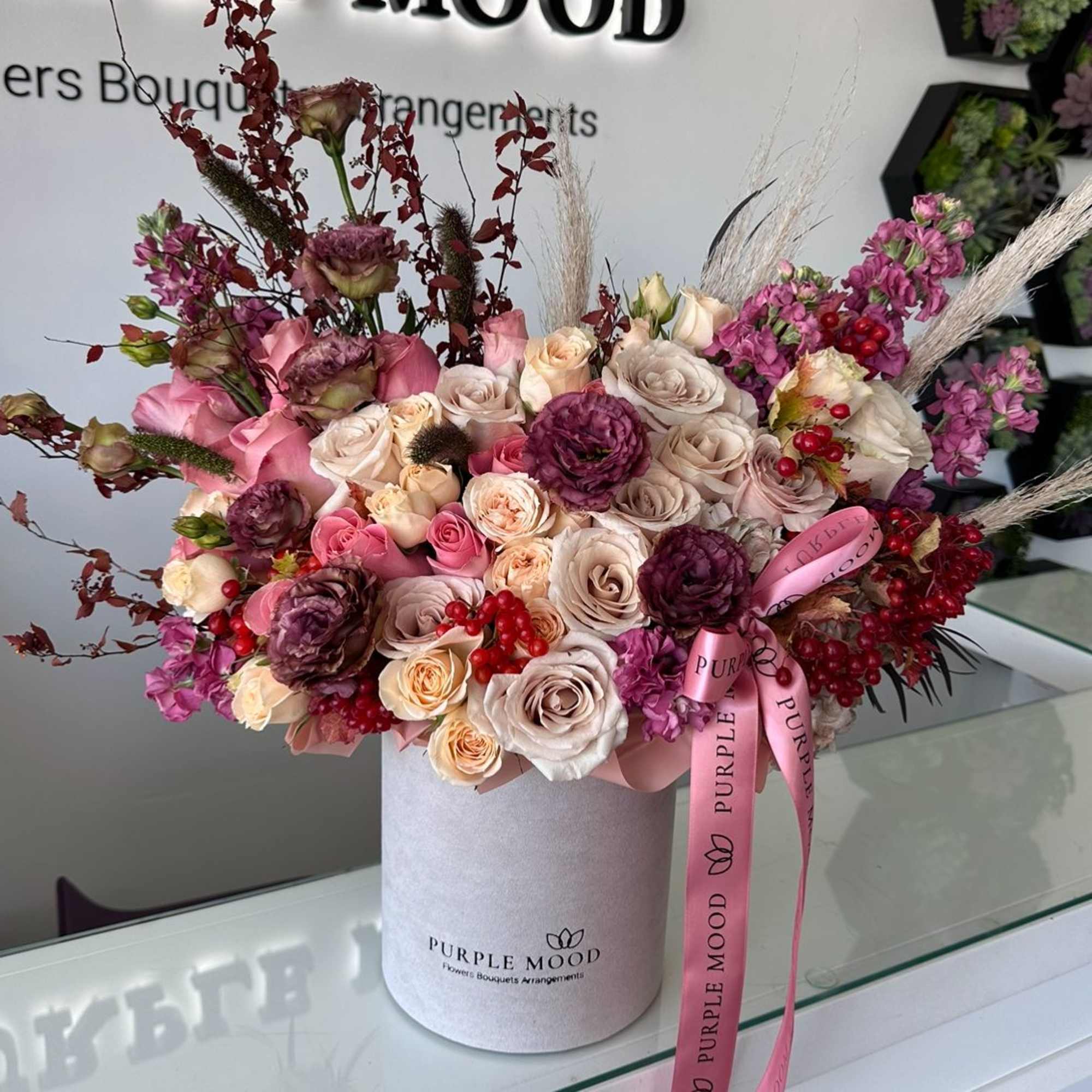 Pink and cream rose bouquet in a round box with a pink ribbon