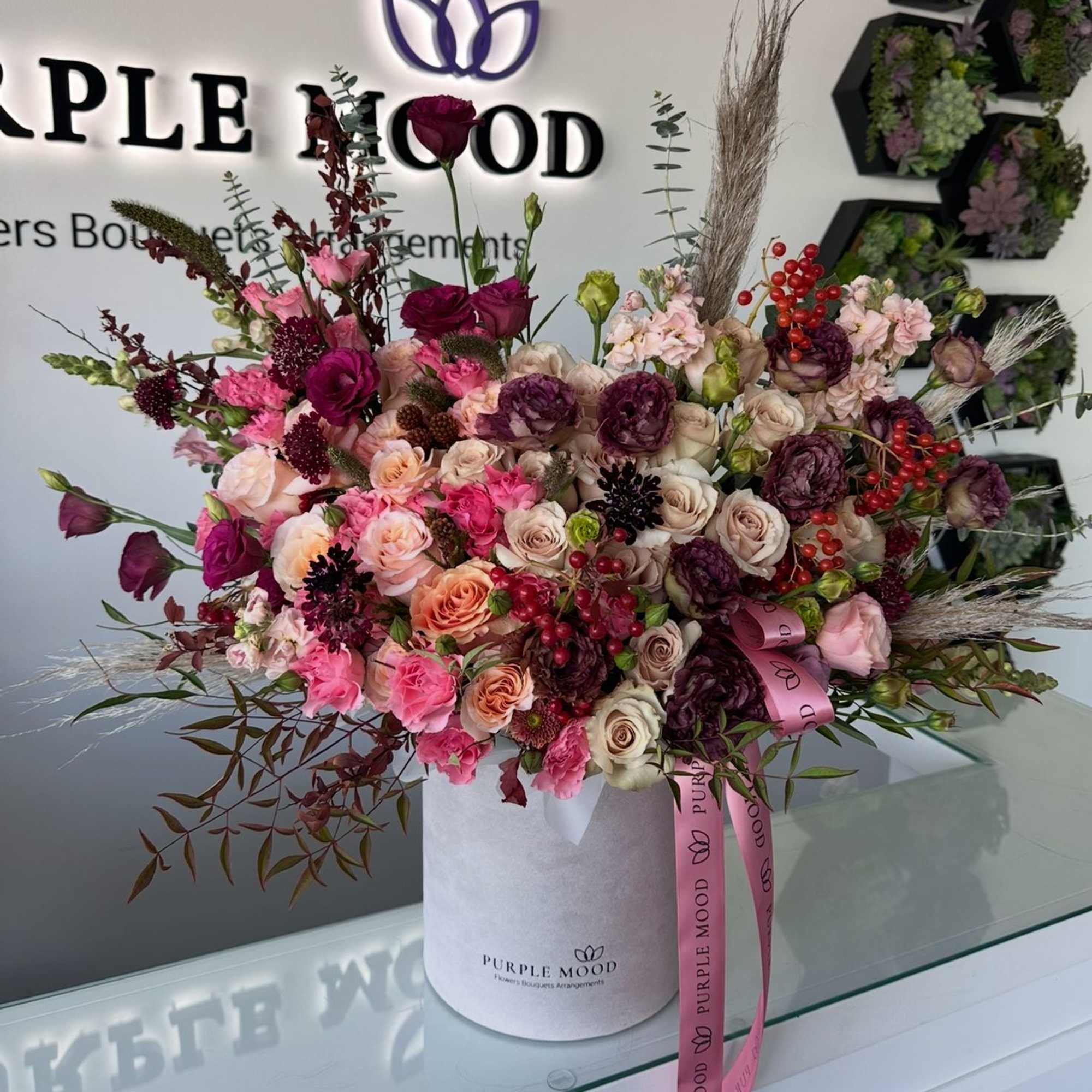 Large mixed bouquet of pink, cream, and burgundy flowers in a white hatbox