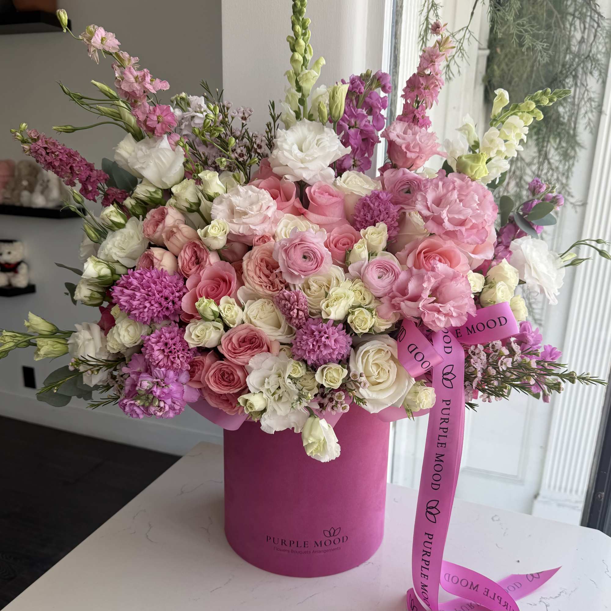 Pink and white mixed bouquet in a magenta hatbox with a ribbon