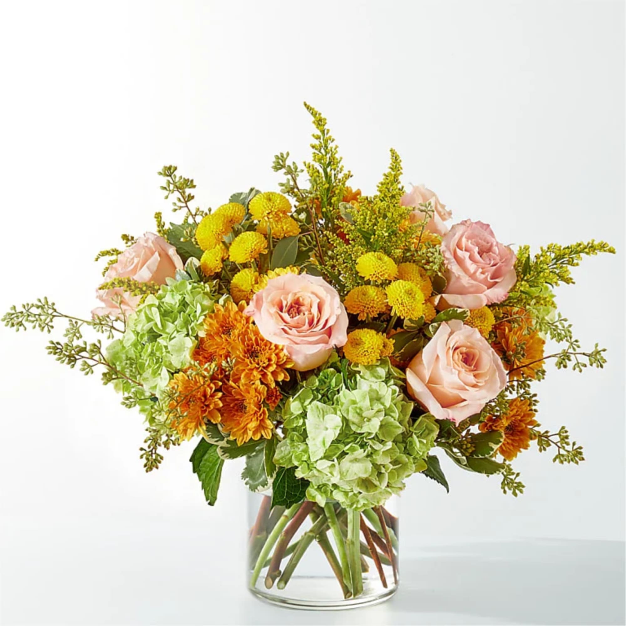Pink roses and yellow-orange flowers in a clear glass vase