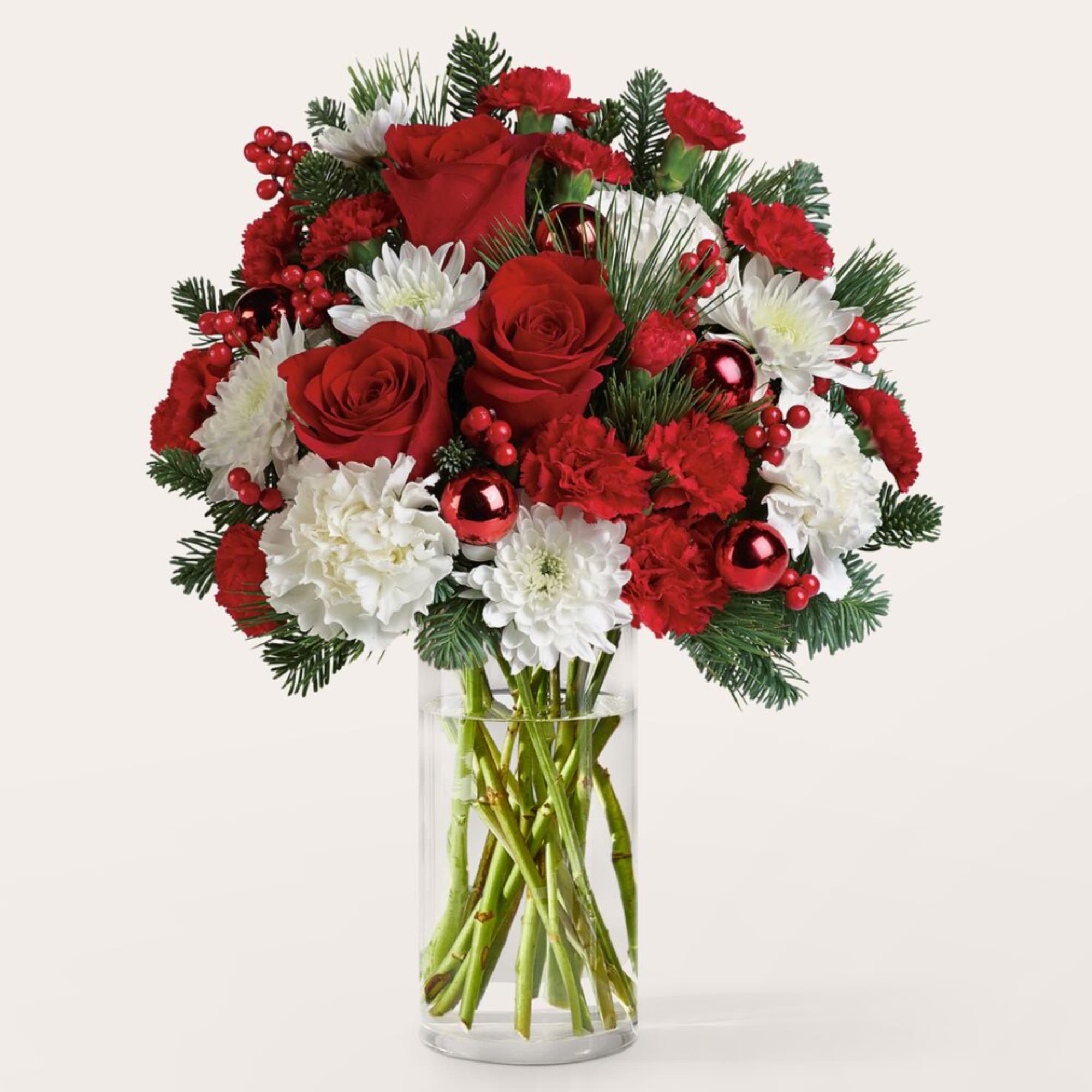 Red roses and white flowers in a clear glass vase