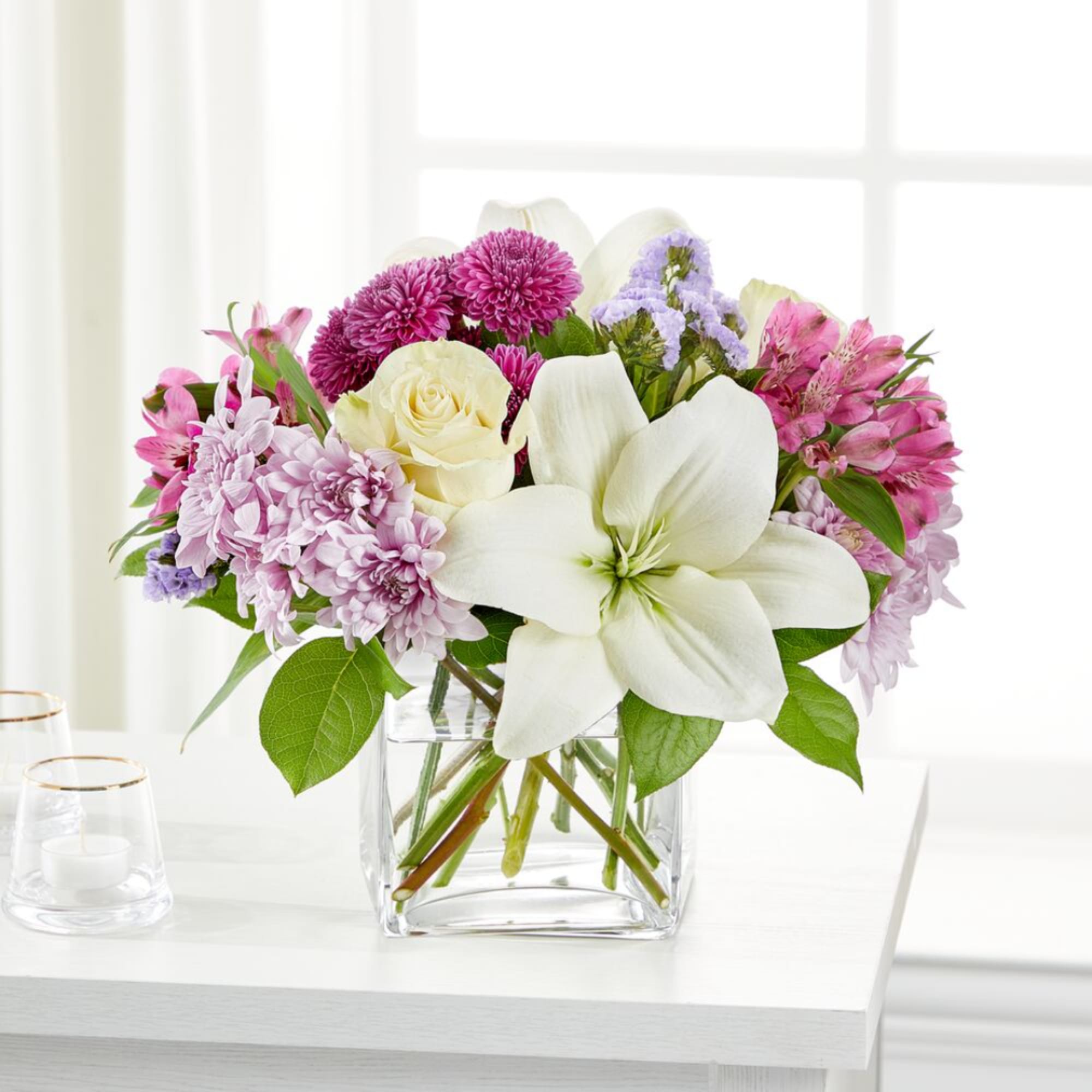 Mixed pink and white flowers arranged in a clear glass vase