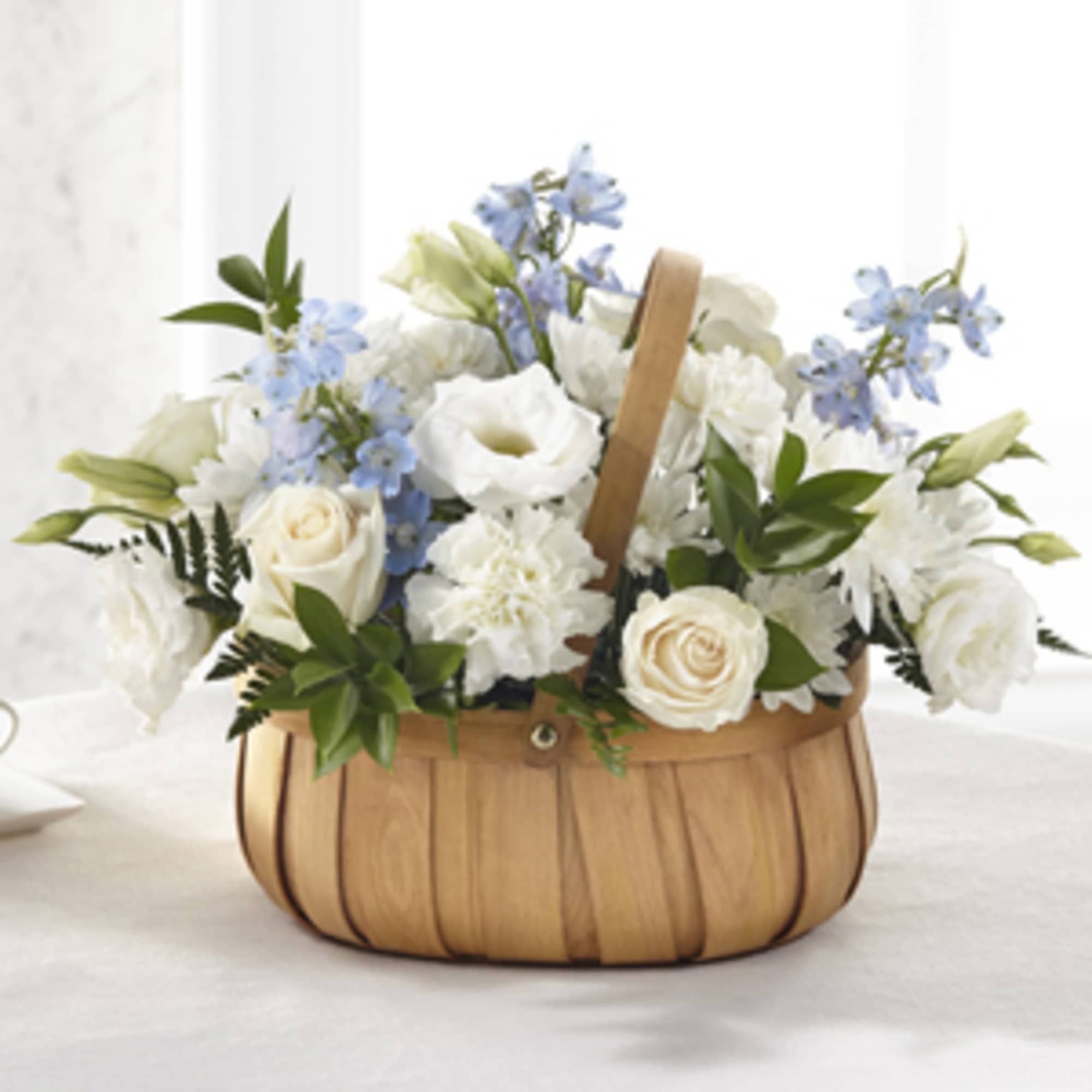 White and blue flowers arranged in a woven basket