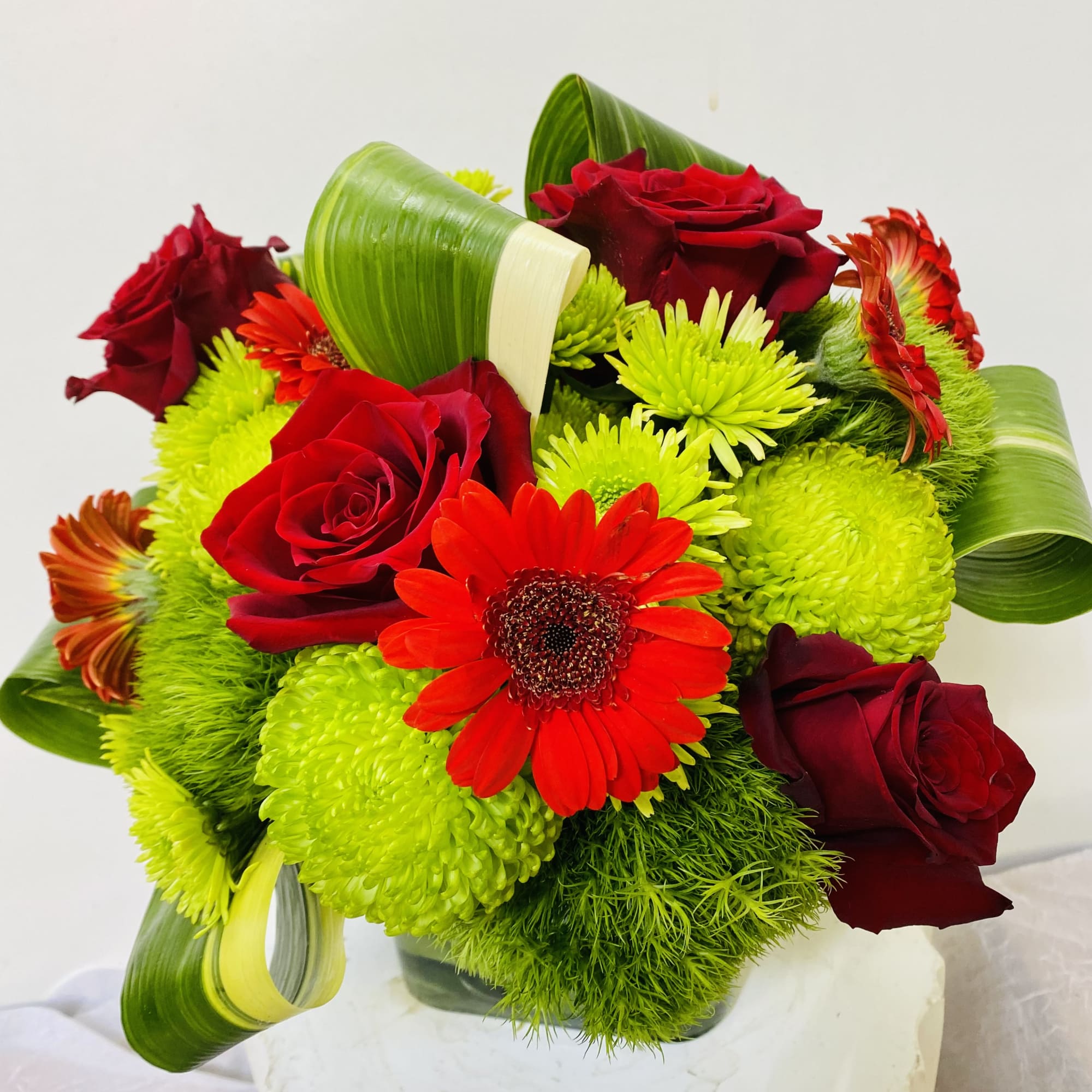 Bouquet of red roses and bright green chrysanthemums with a red gerbera daisy