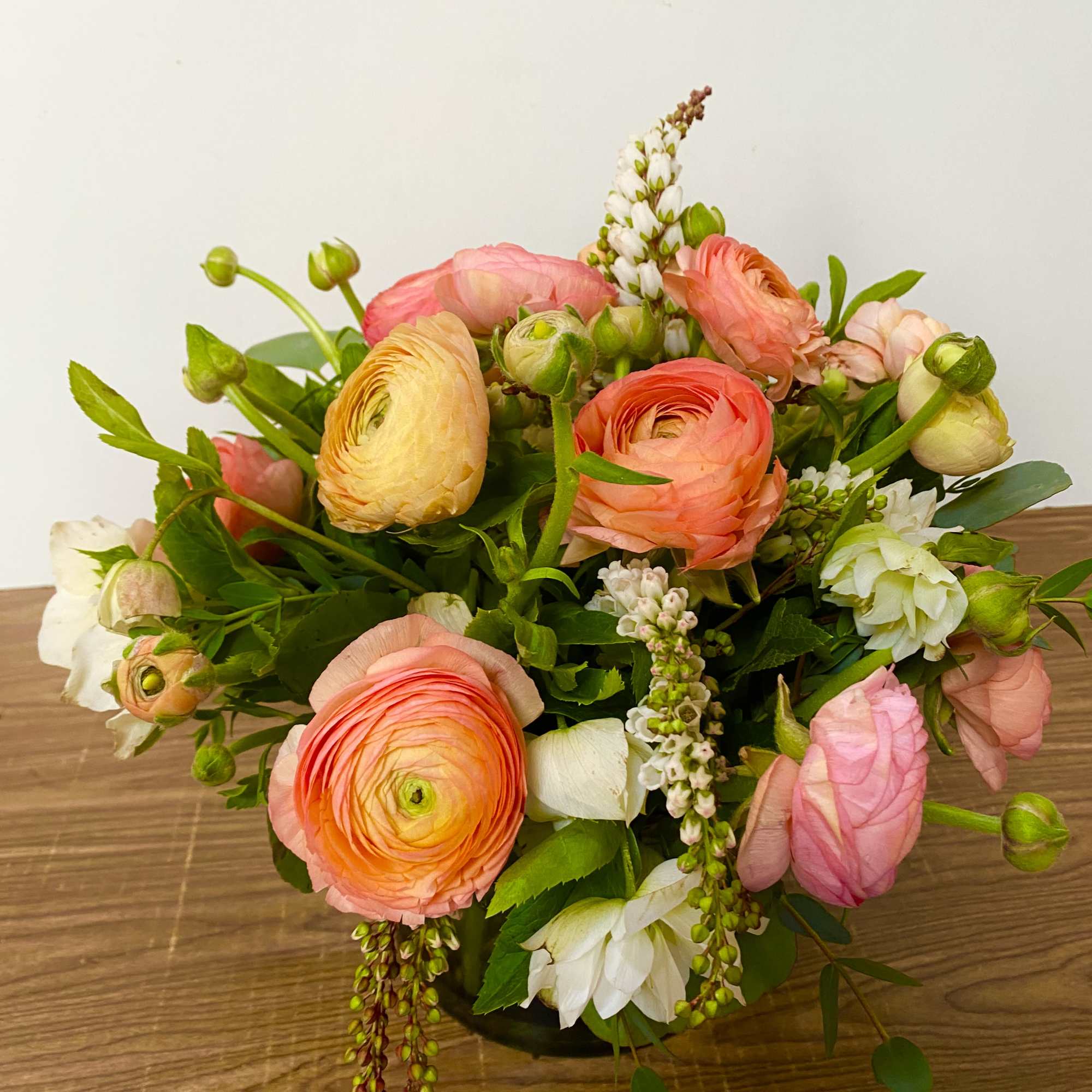 Mixed bouquet of pink, peach, and white flowers on a table