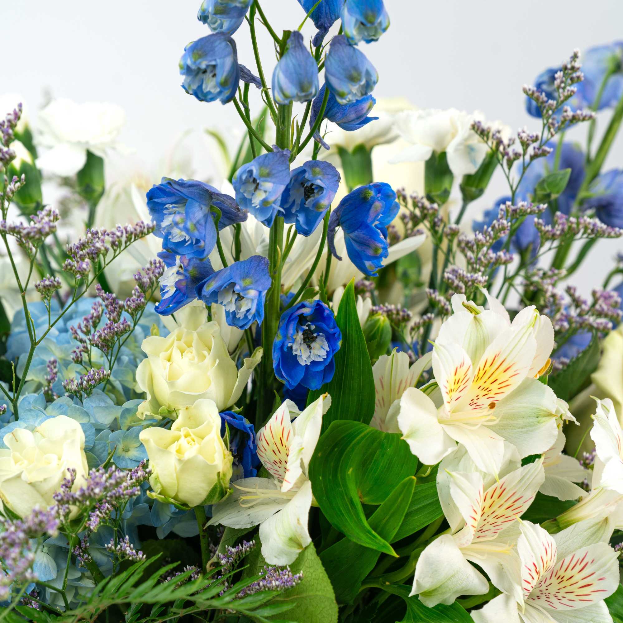 Tall blue delphinium with white roses and alstroemeria, blue hydrangeas and purple filler flowers