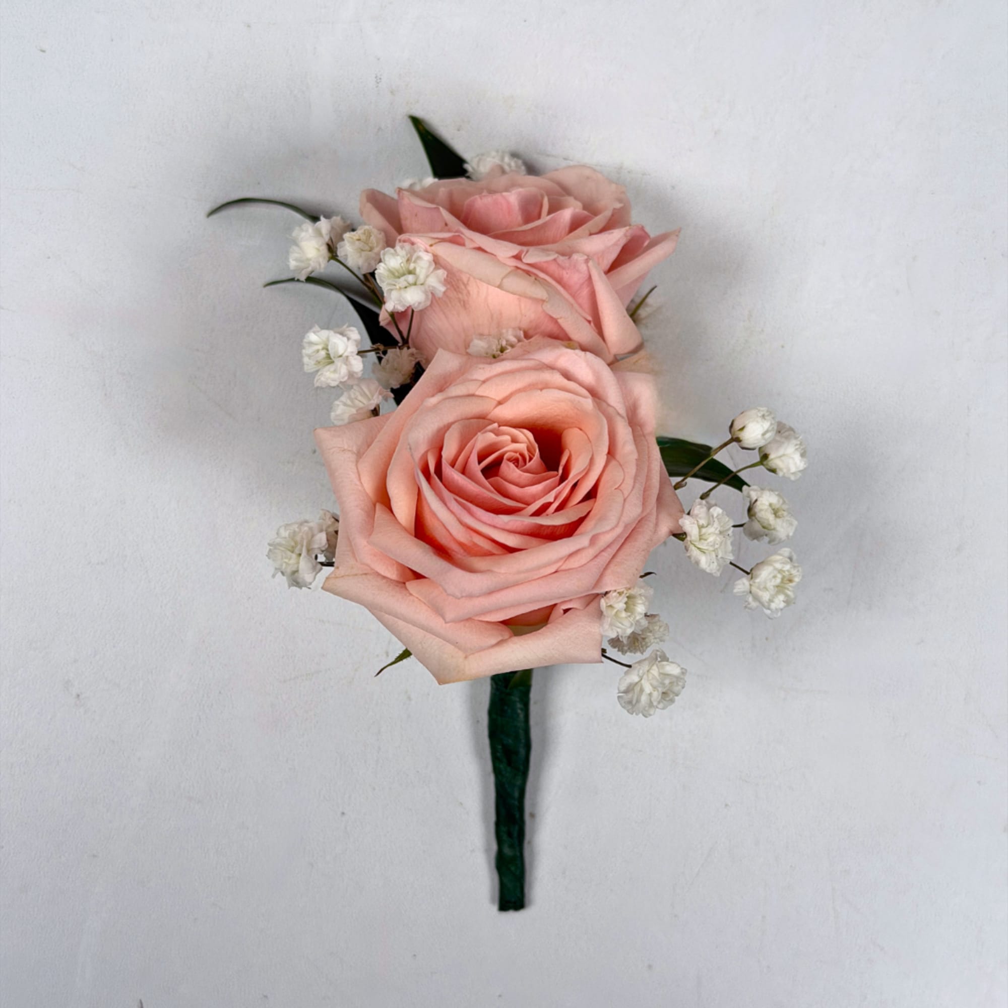 Two pale blush roses sit snugly together in this Rose Quartz boutonniere