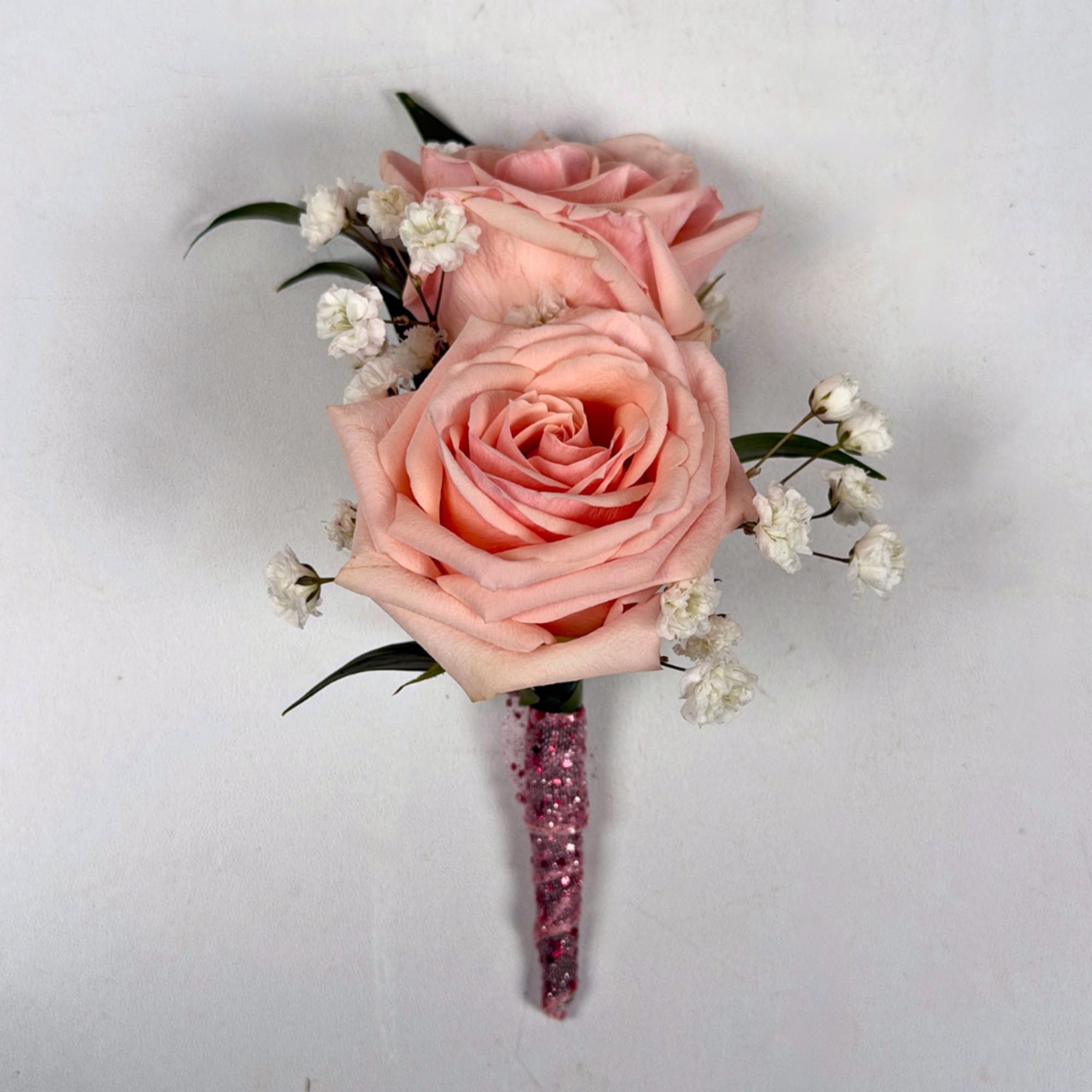 Two pale blush roses sit snugly together in this Rose Quartz boutonniere
