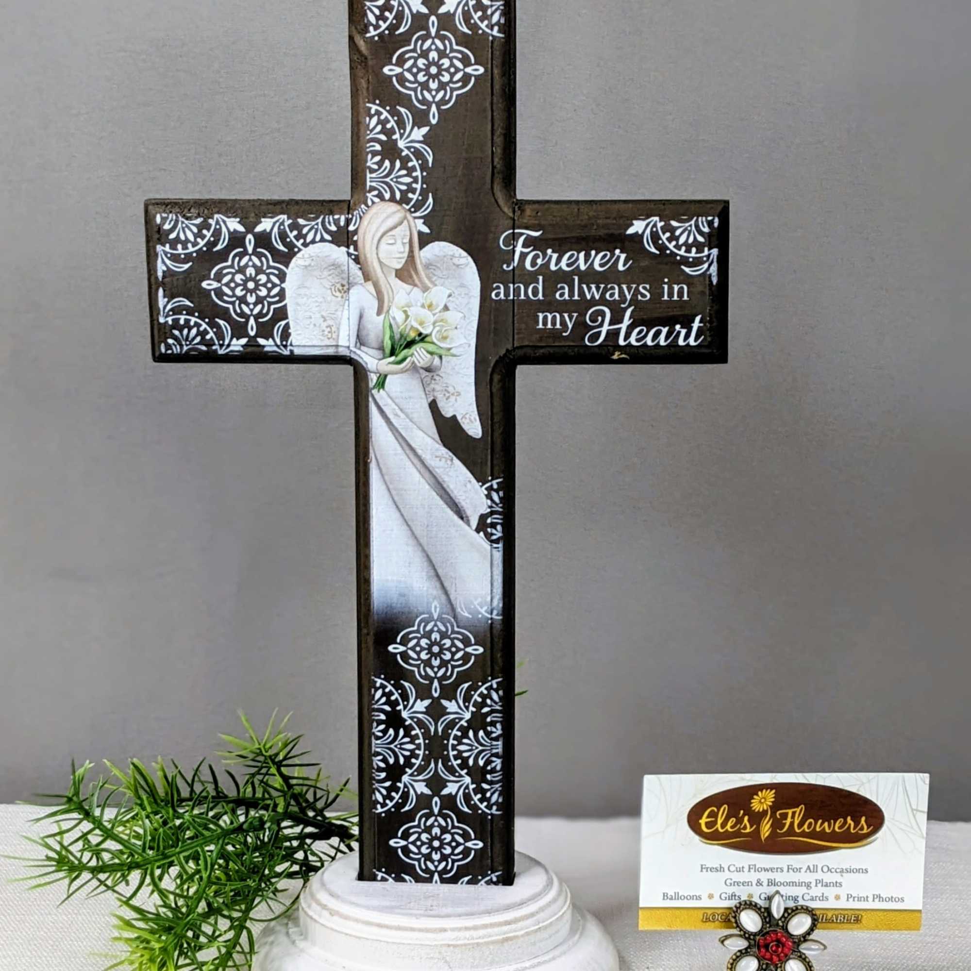 Decorative memorial cross with an angel and flowers on a pedestal base