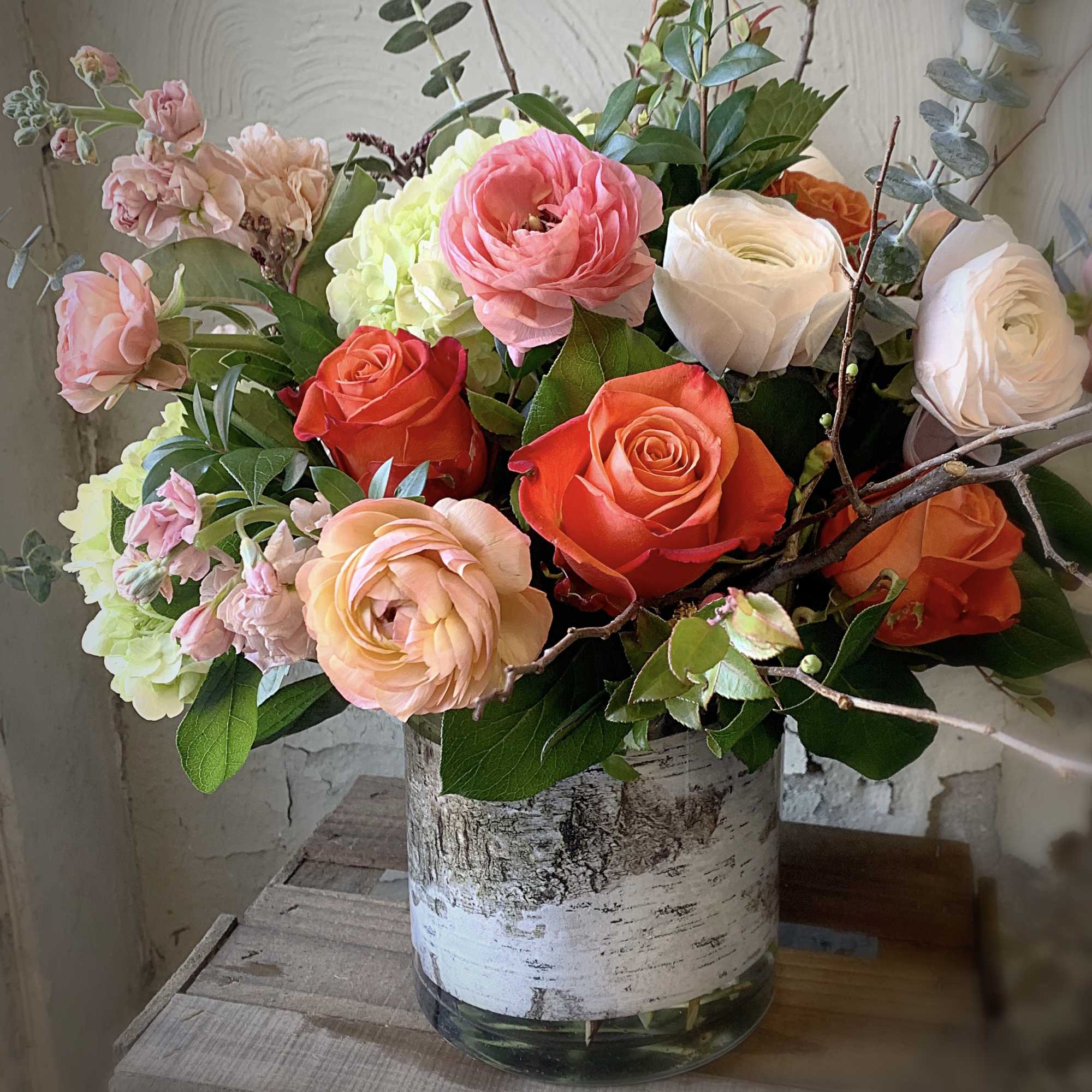 Mixed bouquet of roses and hydrangeas in a birch-style vase