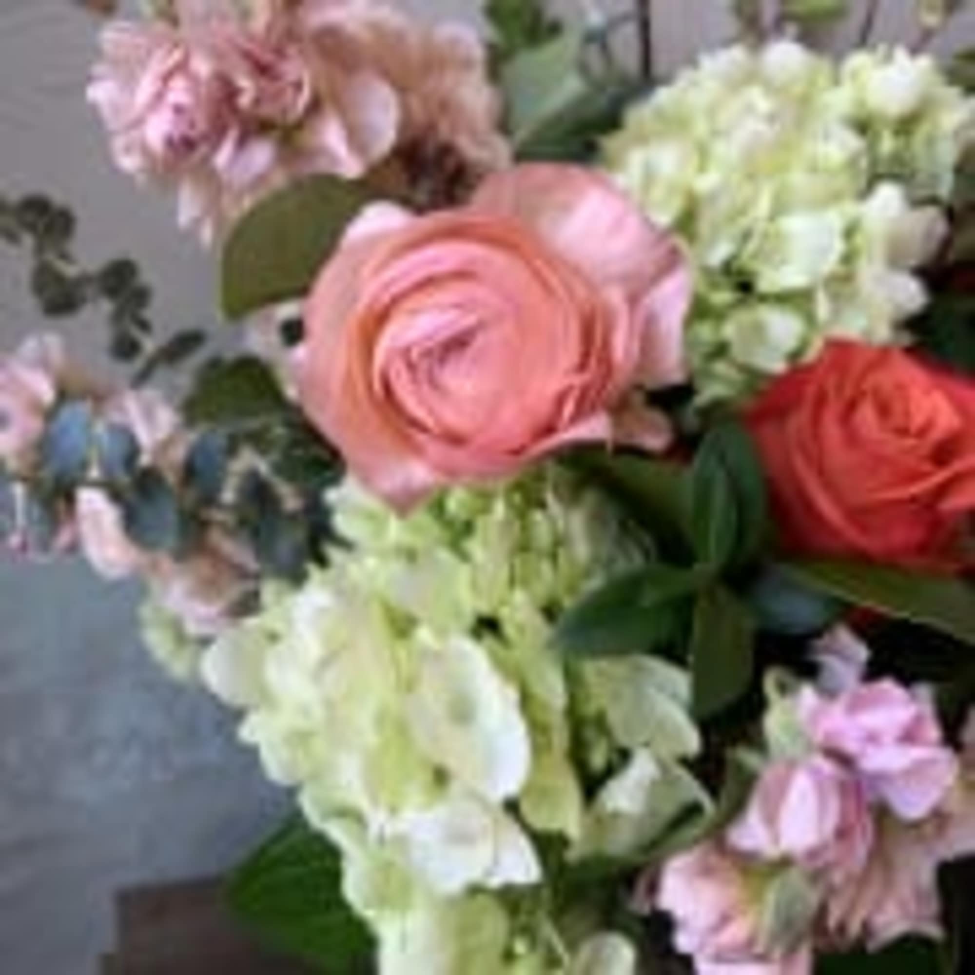 Bouquet of pink and red roses with pale hydrangeas