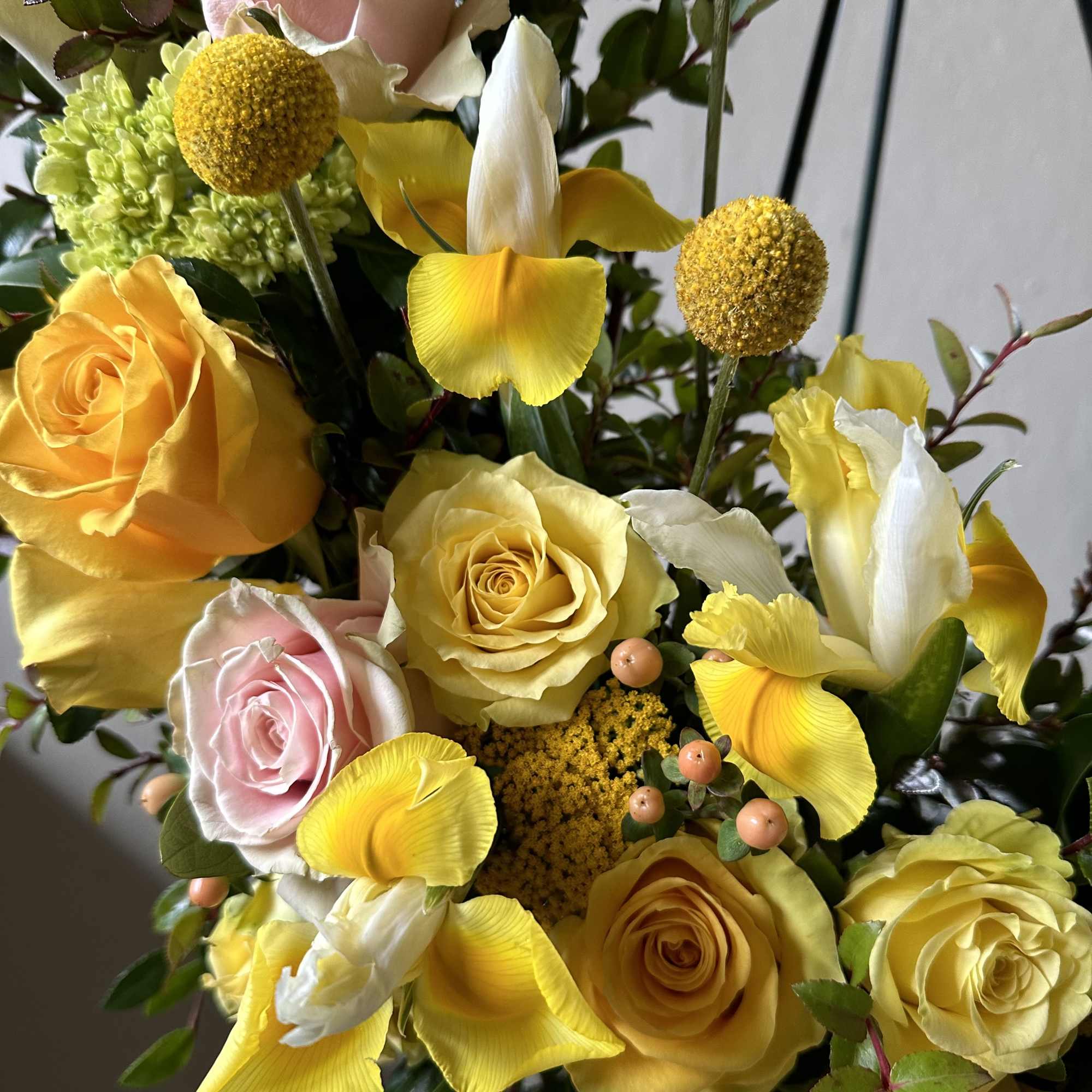 Yellow and pink roses with white and yellow iris in a bouquet