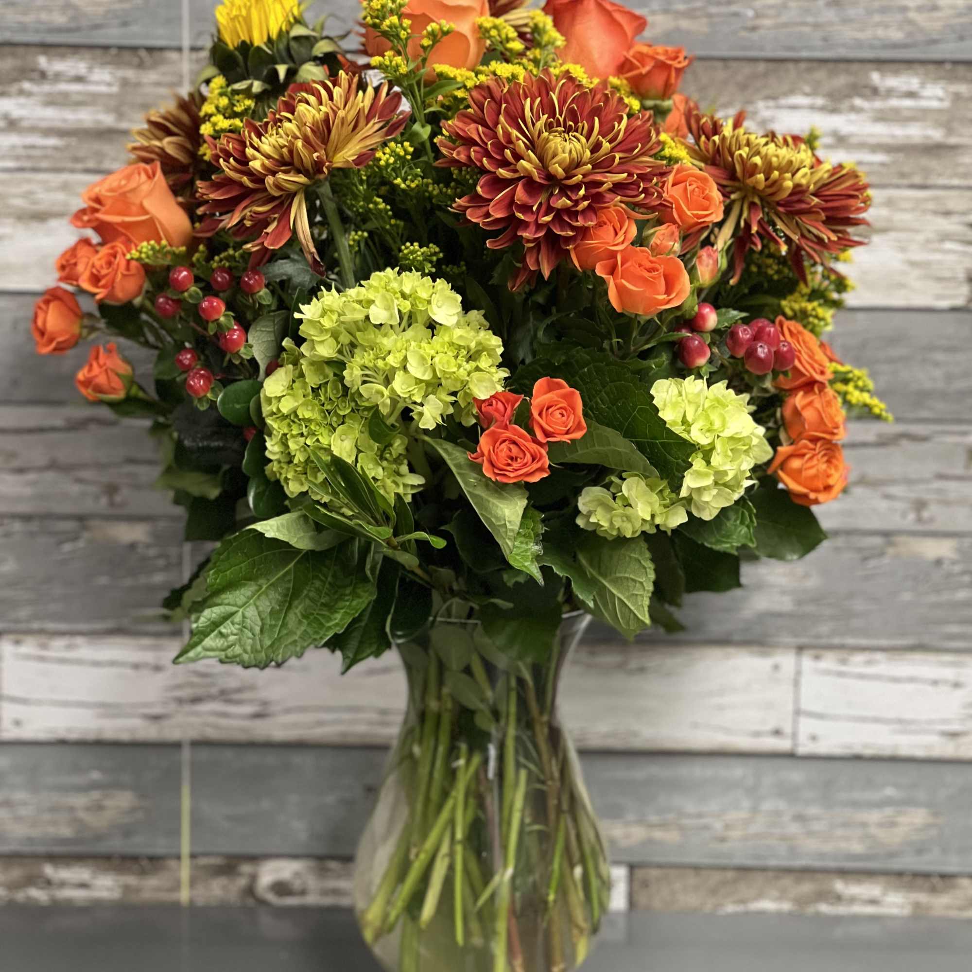 Orange roses and chrysanthemums in a glass vase