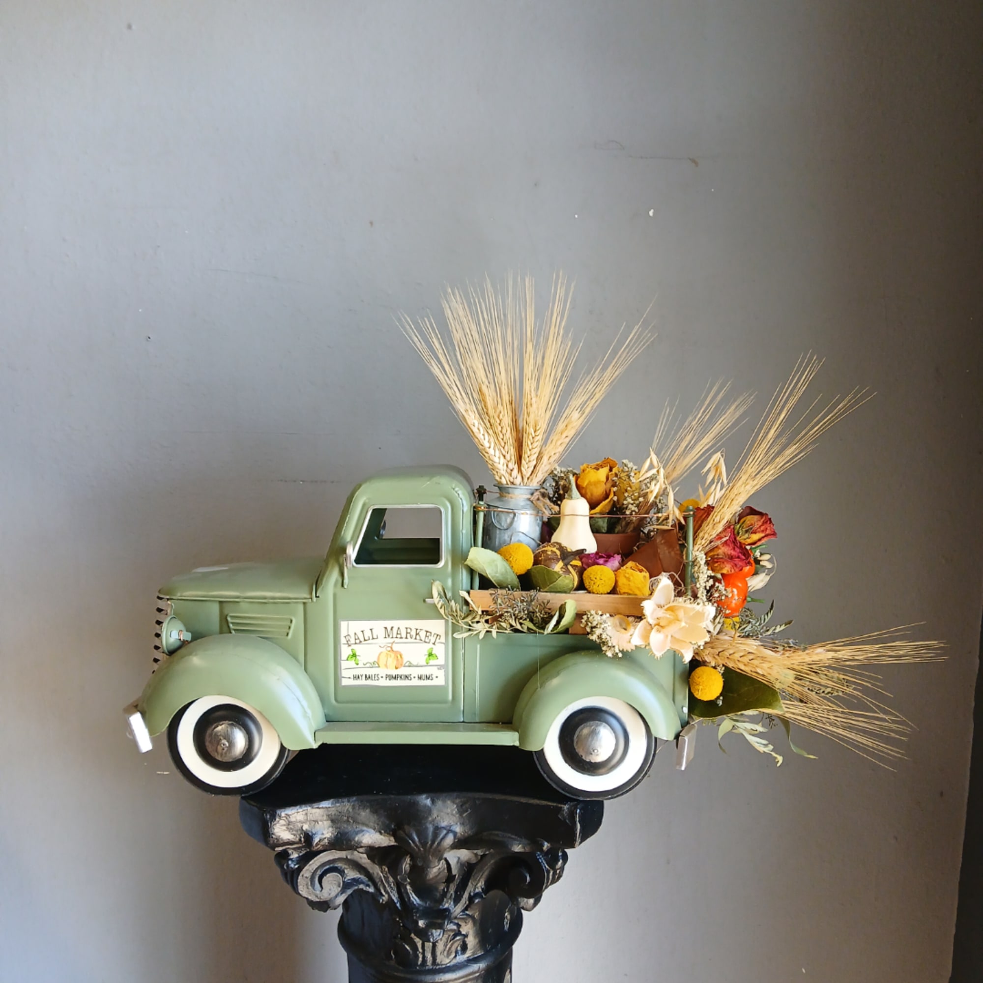 Vintage green truck filled with dried flowers and wheat