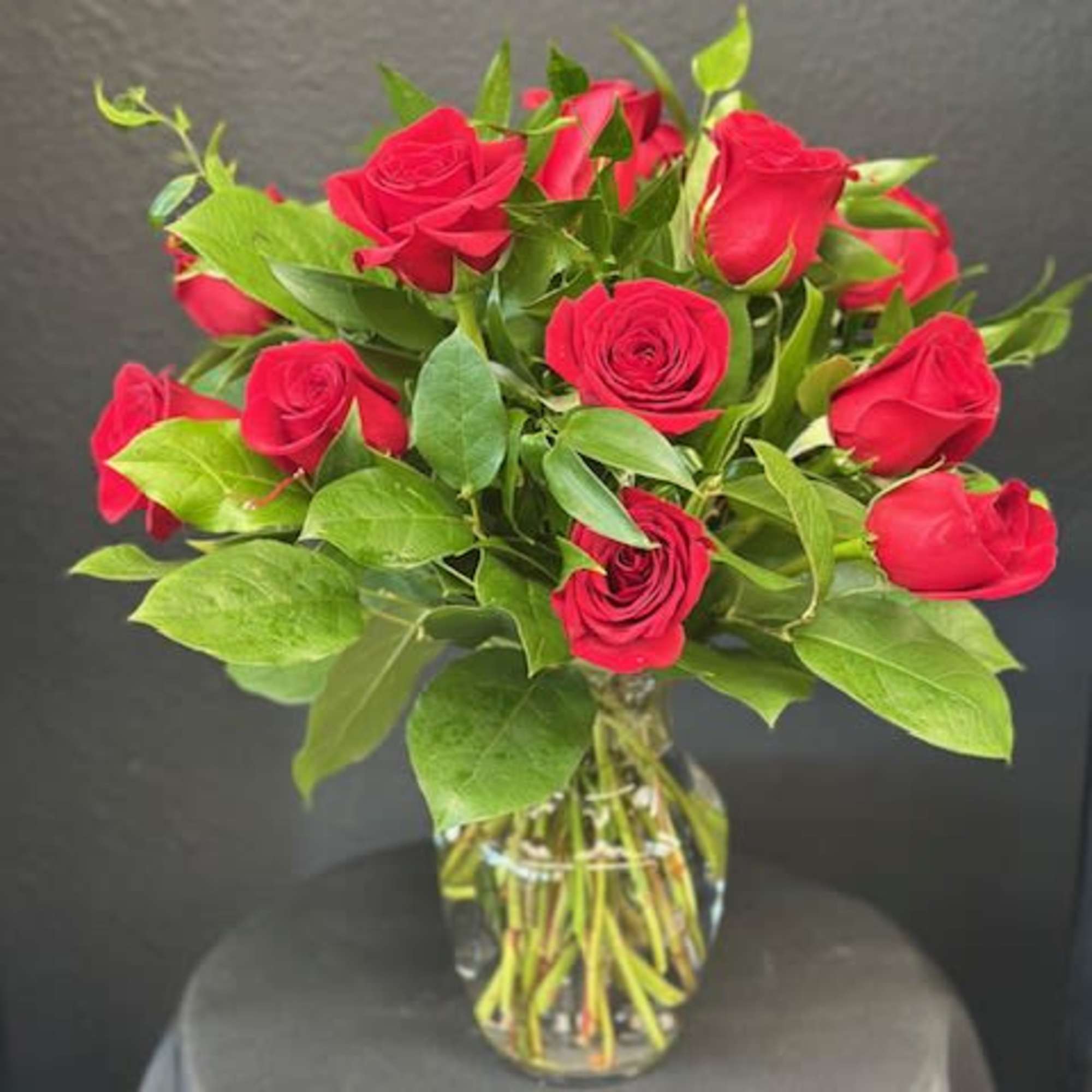 Red roses arranged in a clear glass vase