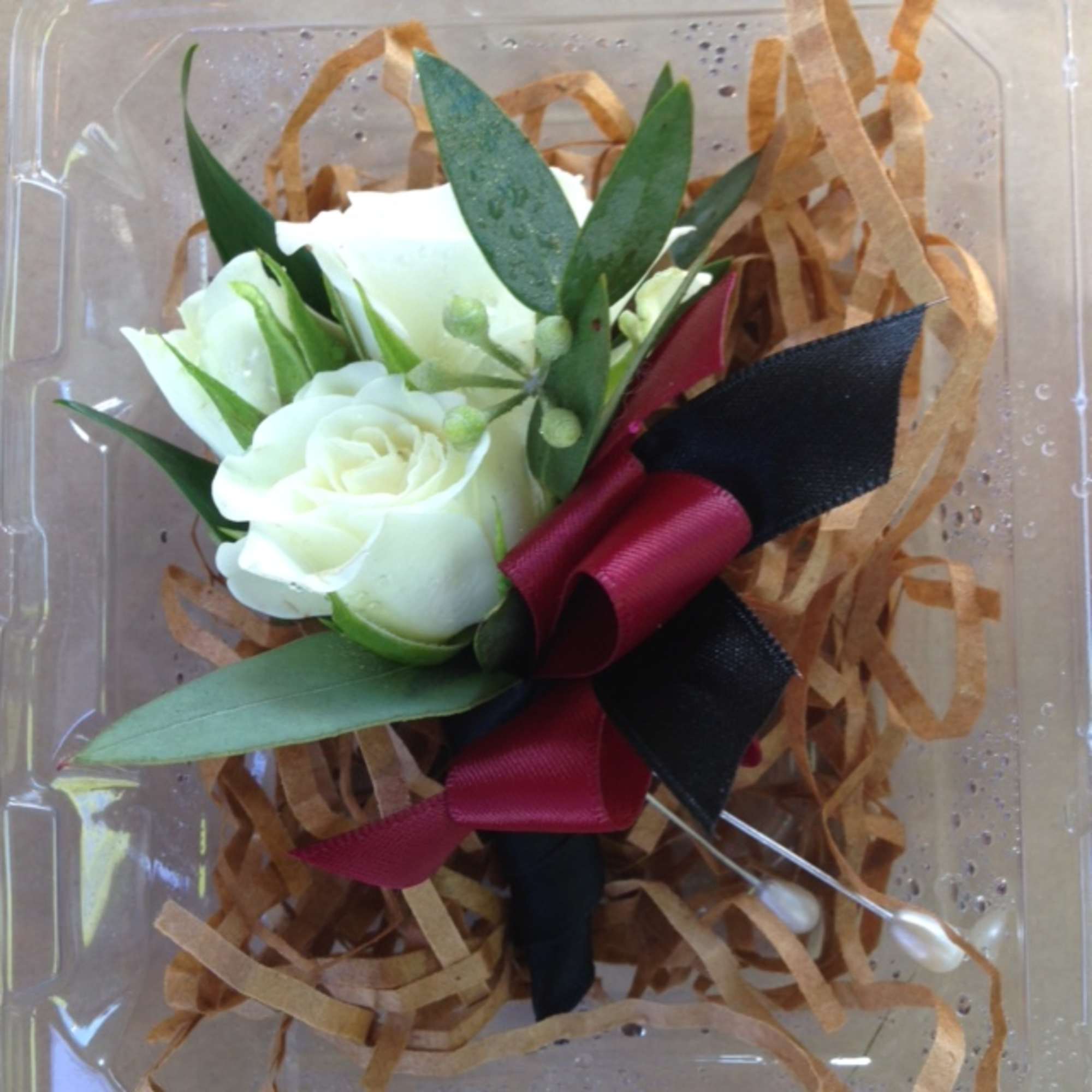 White rose boutonniere with burgundy and black ribbon