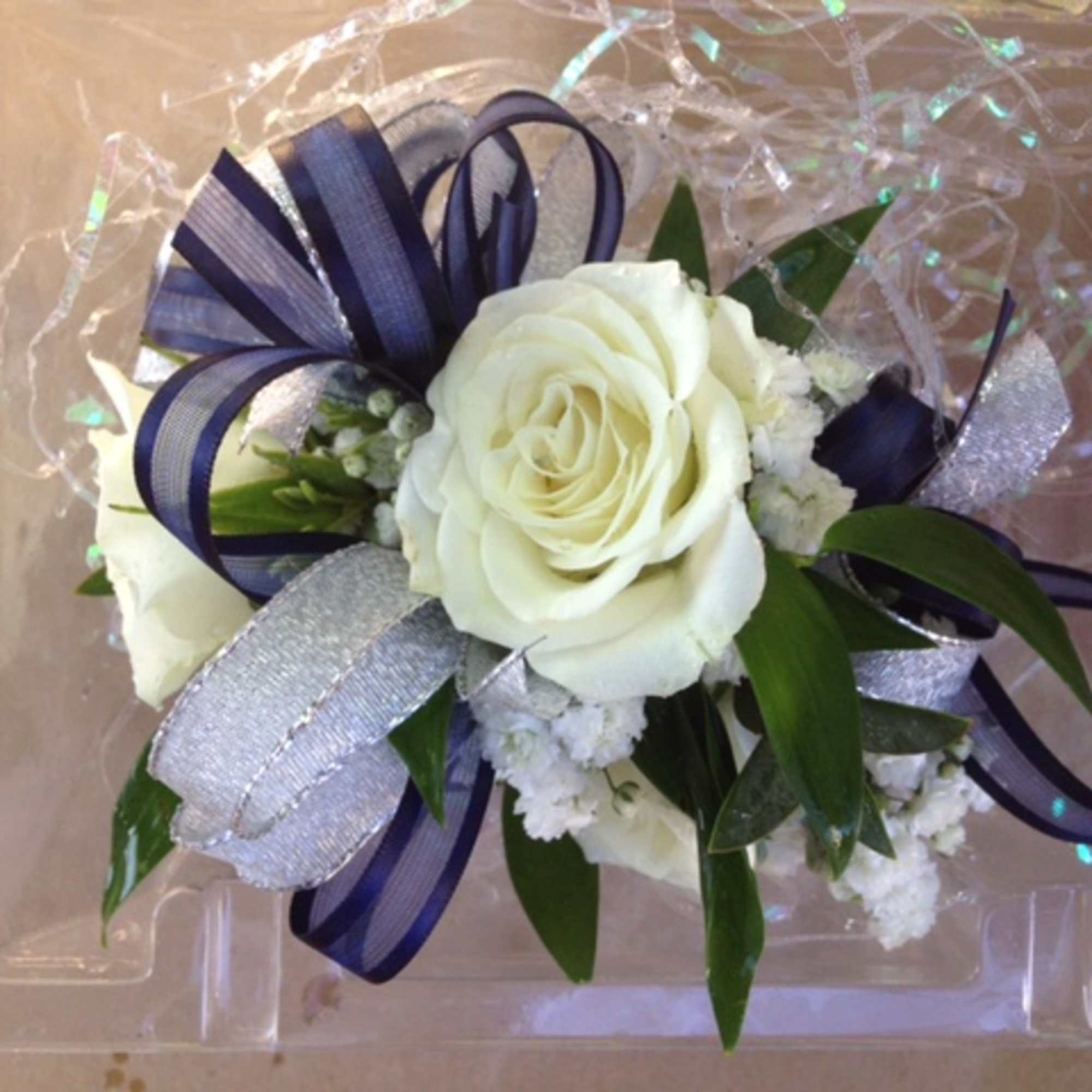 White rose corsage with navy and silver ribbon