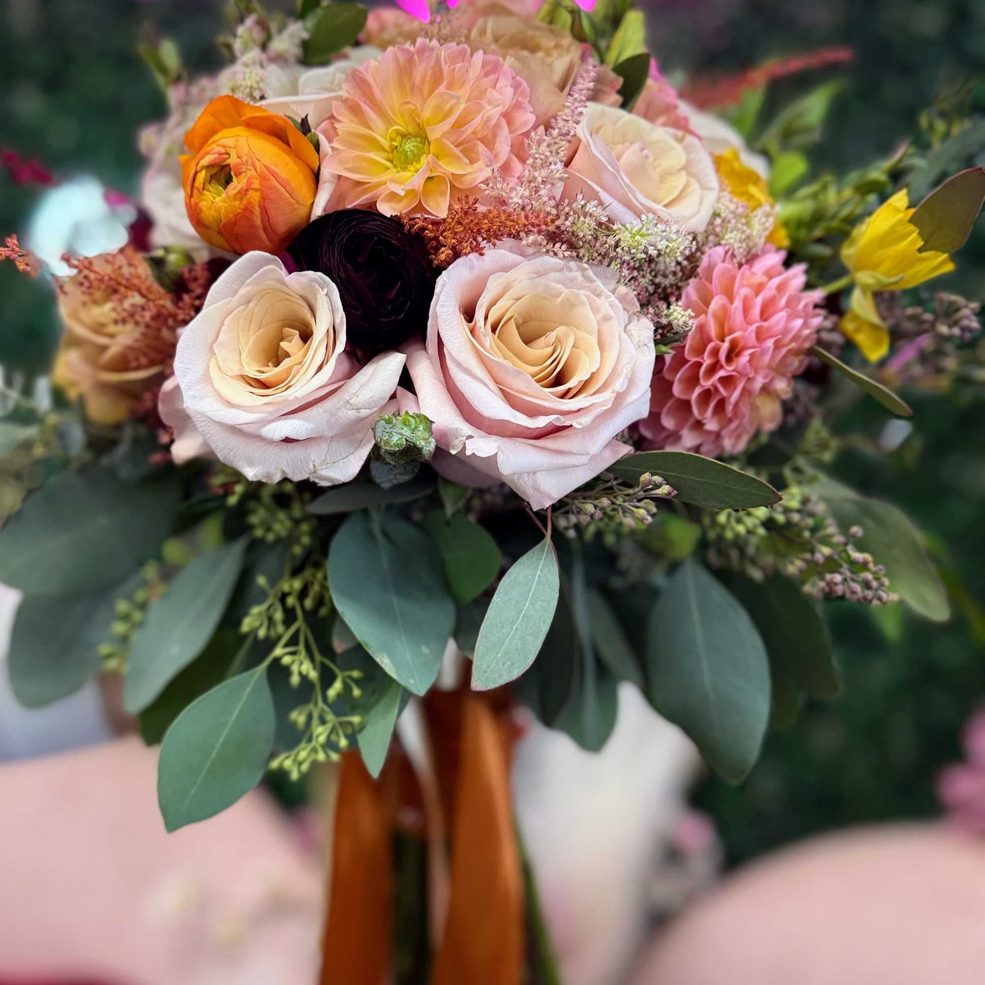 Bouquet of pale pink and peach roses with mixed blooms and greenery