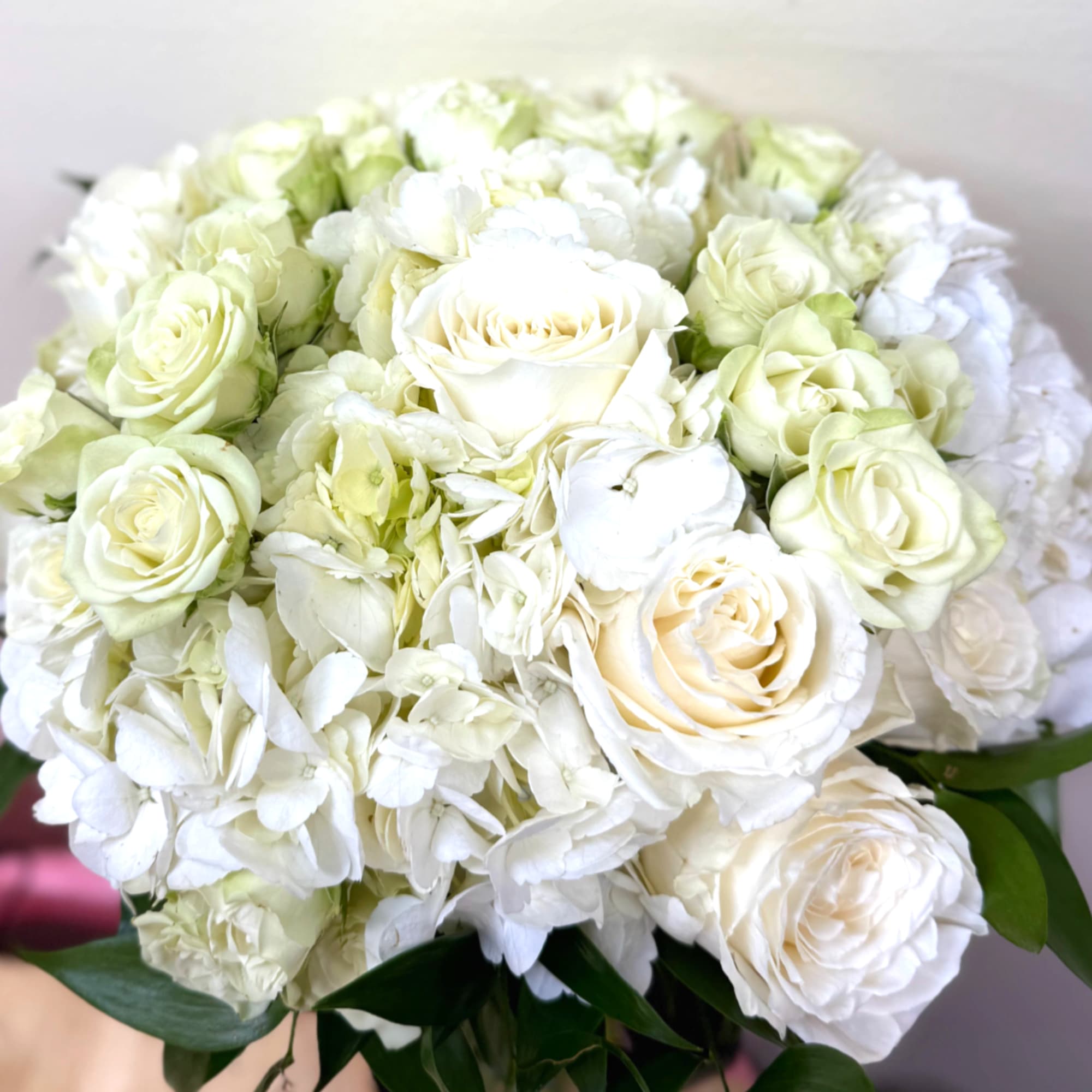 A timeless off-white bridal bouquet featuring lush hydrangeas paired with a mix