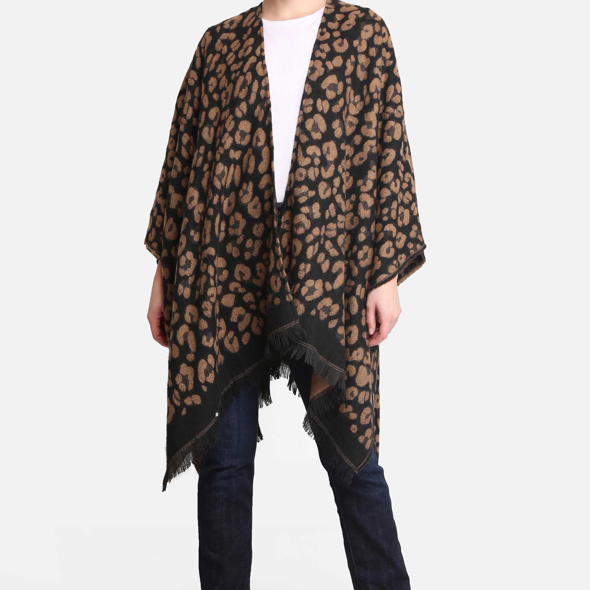 Woman modeling a brown and black leopard print poncho with fringe hem