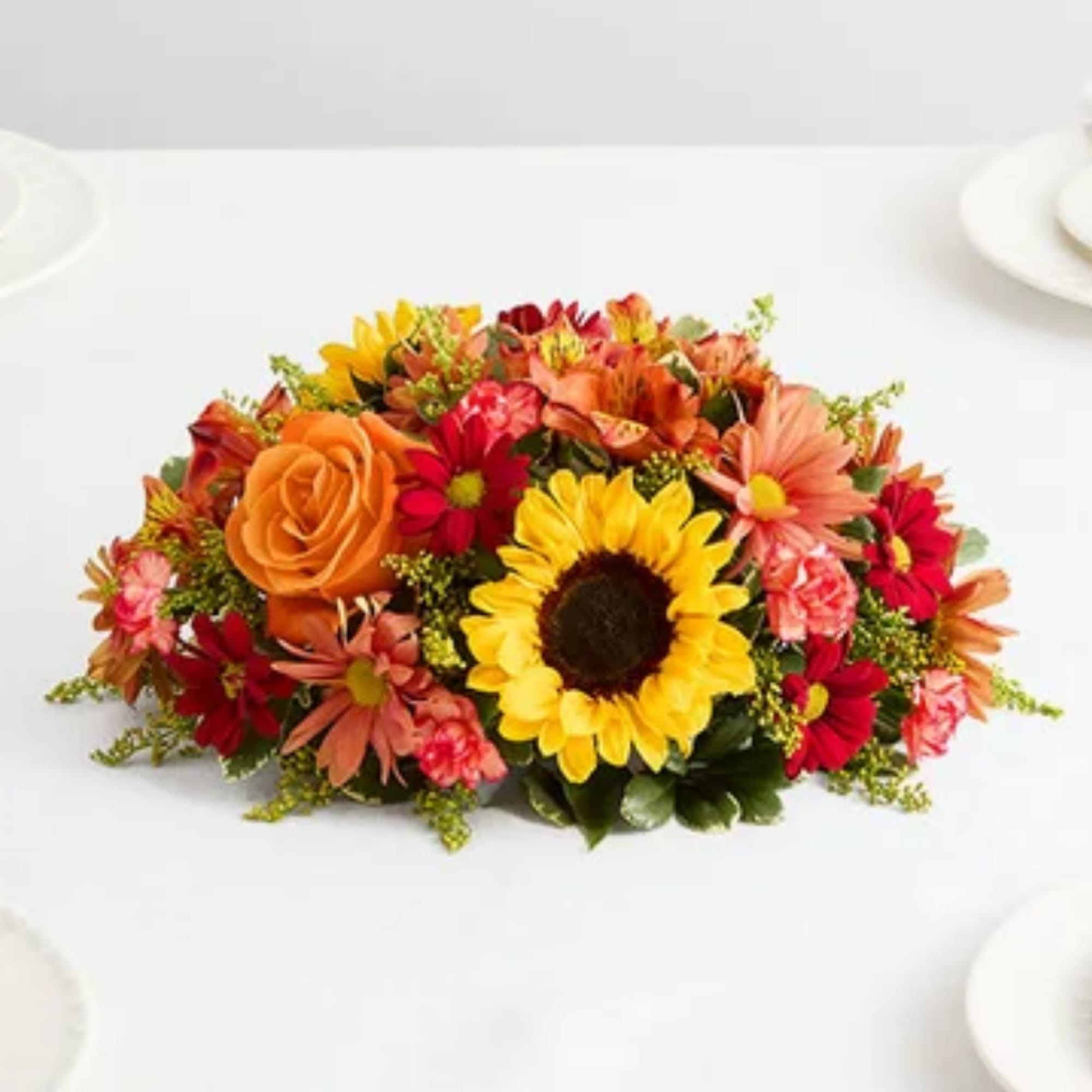 Bright mixed bouquet with sunflowers, orange roses, and red daisies