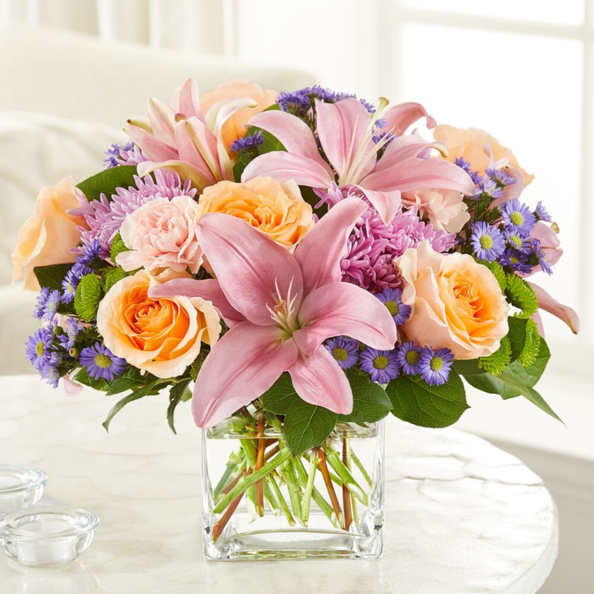 Pink lilies and peach roses in a clear glass vase