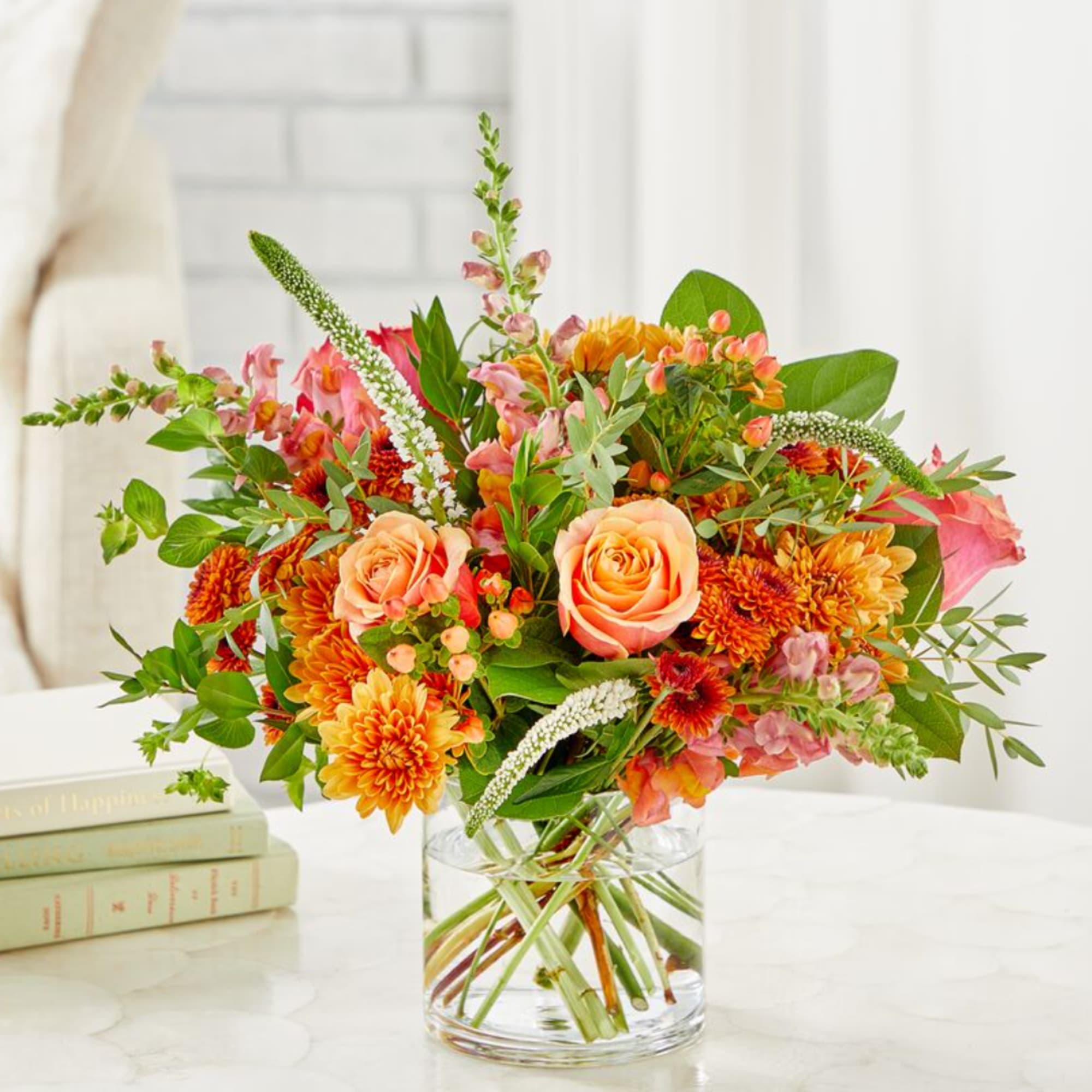 Orange and pink mixed bouquet in a clear glass vase