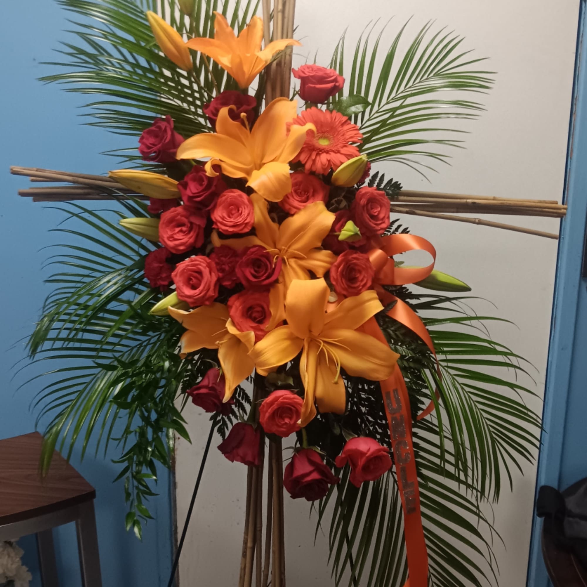 Tall floral standing arrangement with red roses and orange lilies