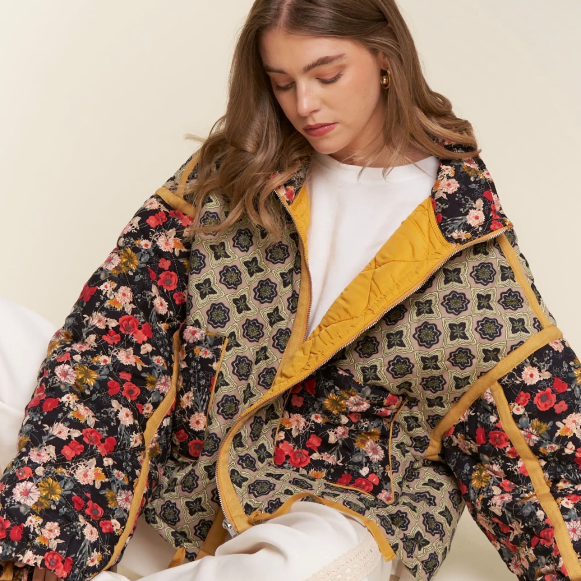 Woman wearing a floral quilted jacket over a white top