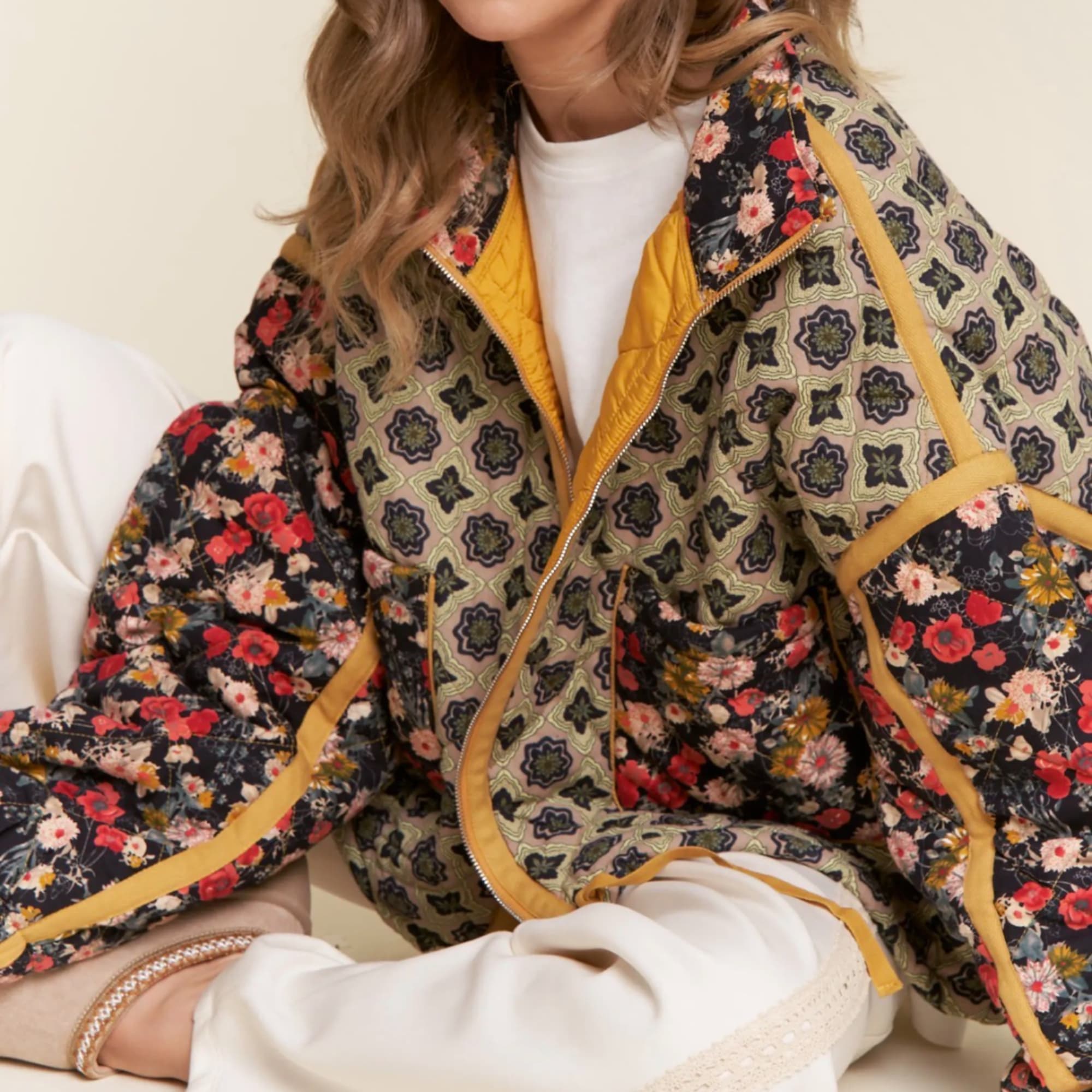Person wearing a patterned floral jacket over white clothing