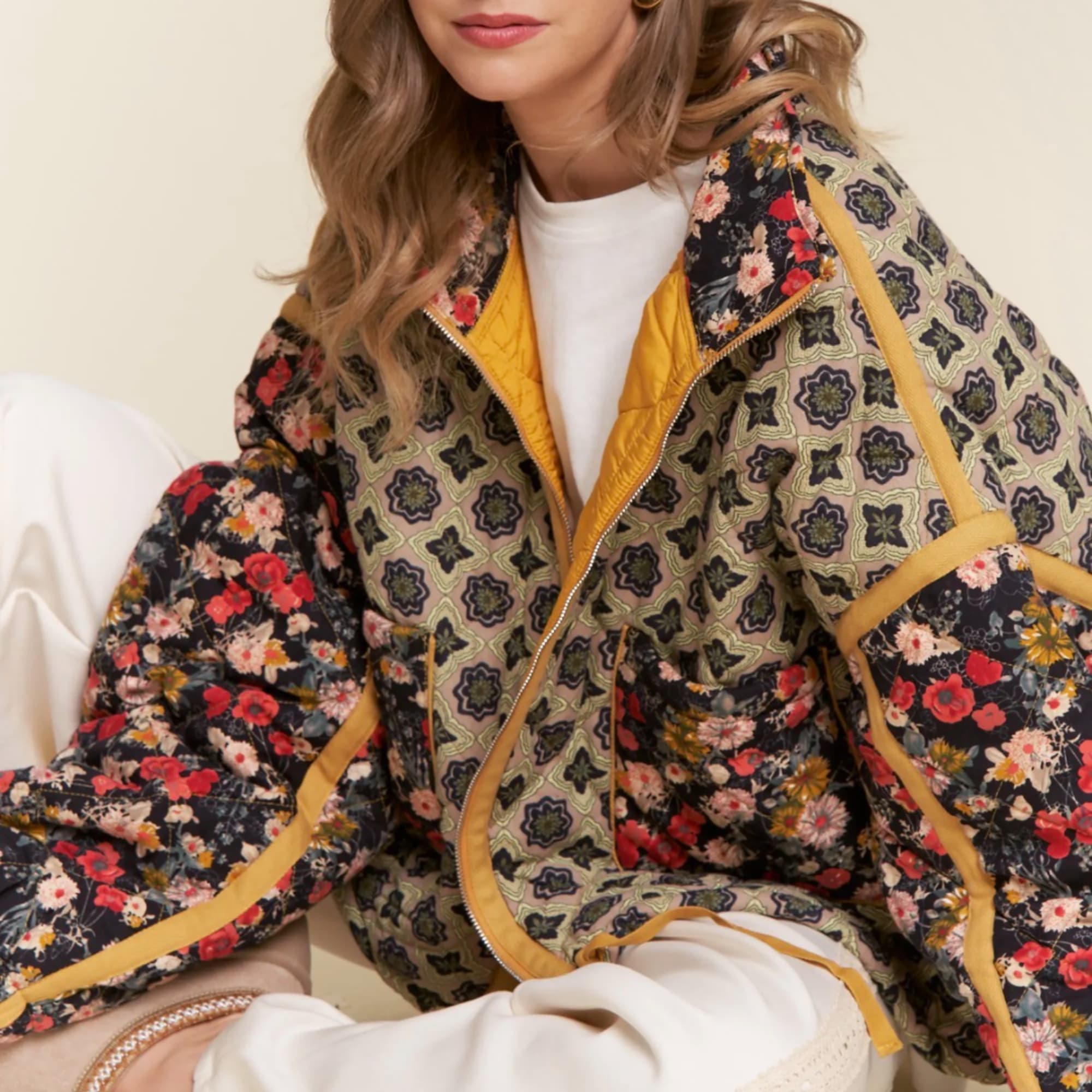 Woman wearing a patterned floral quilted jacket over a white top