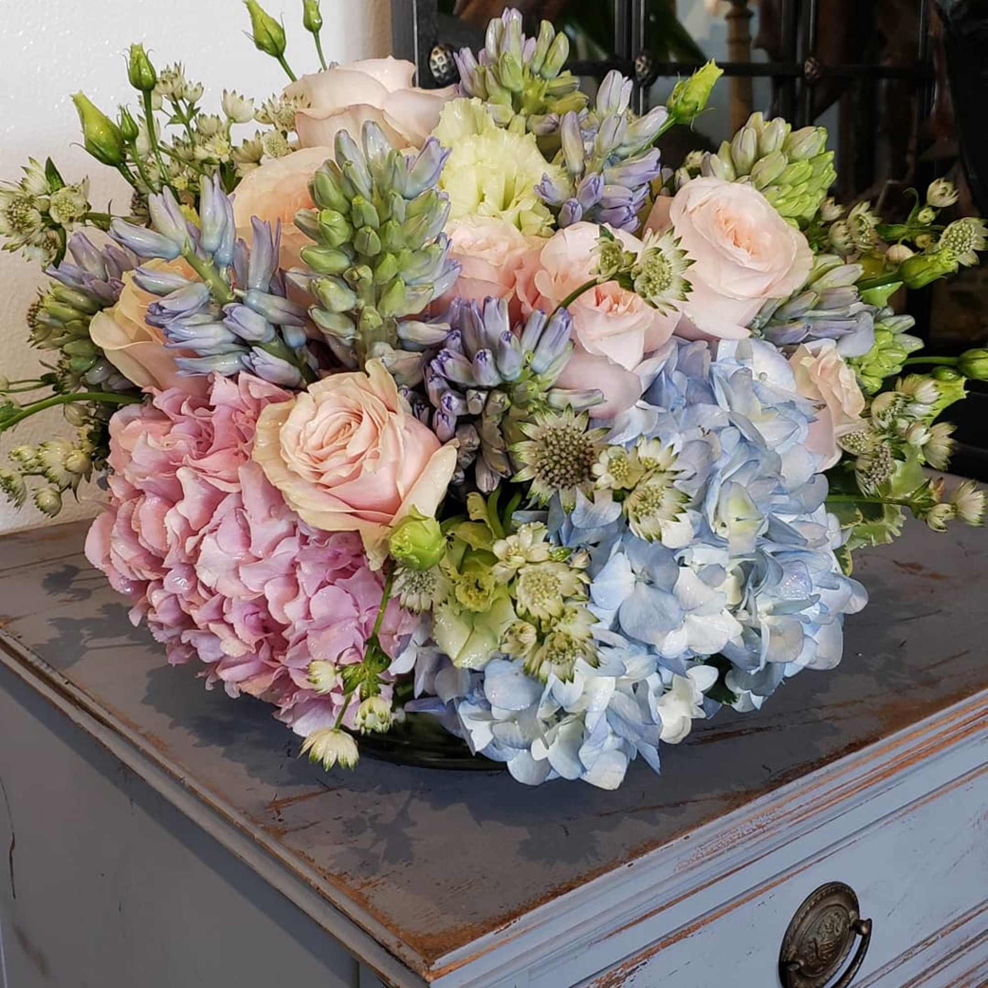 Pastel bouquet of hydrangeas, roses, and small white flowers