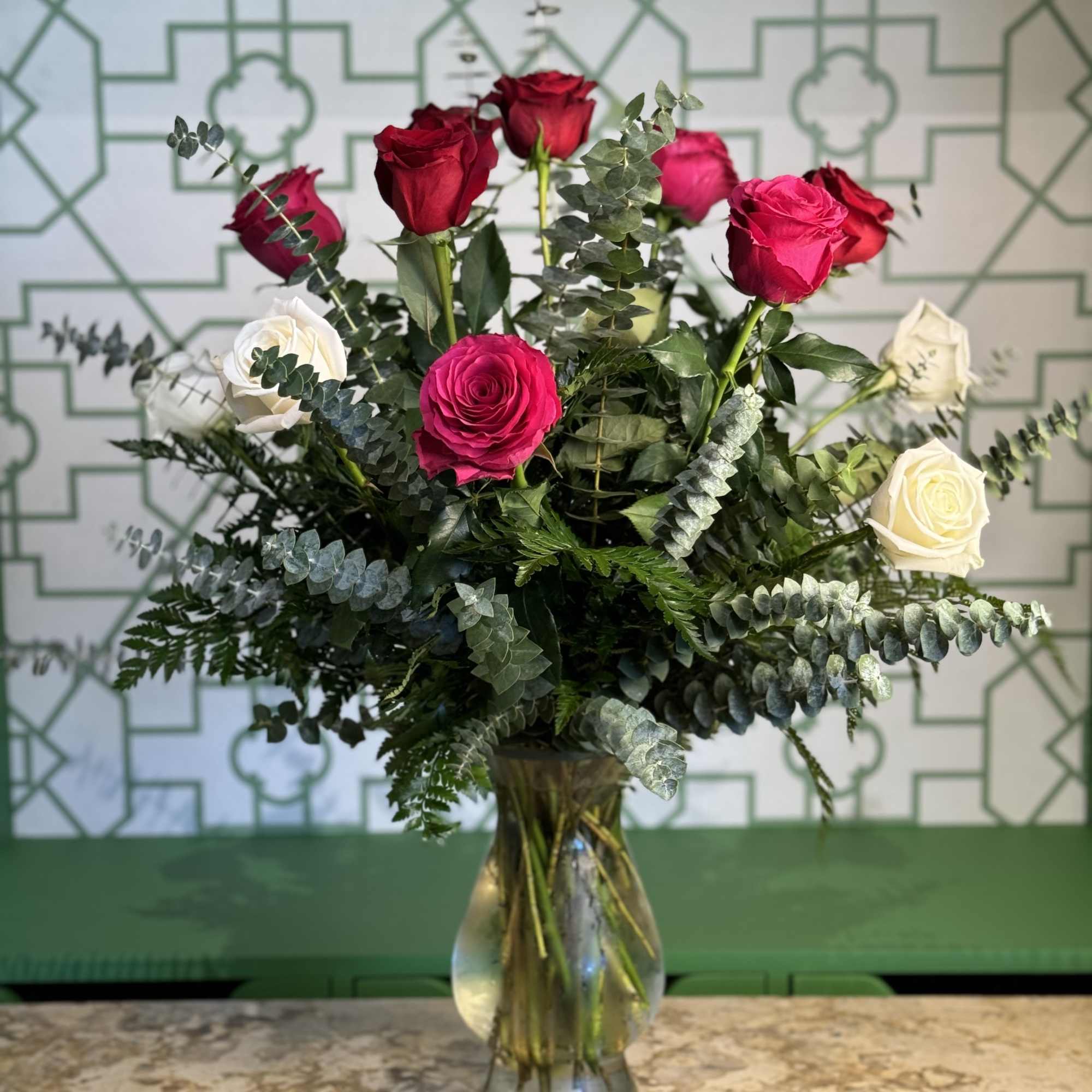 Bouquet of red, pink, and white roses in a glass vase