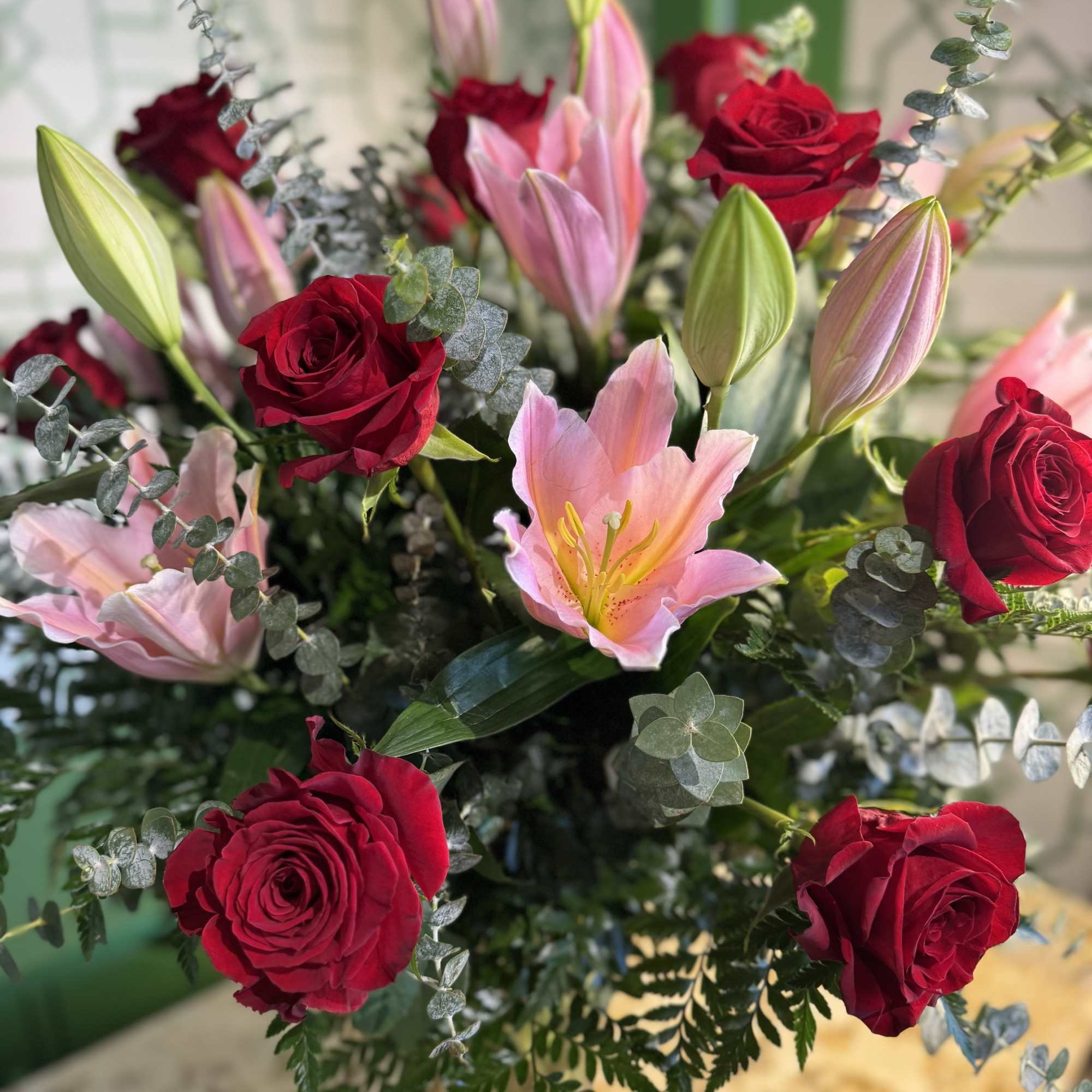 Bouquet of red roses and pink lilies with eucalyptus