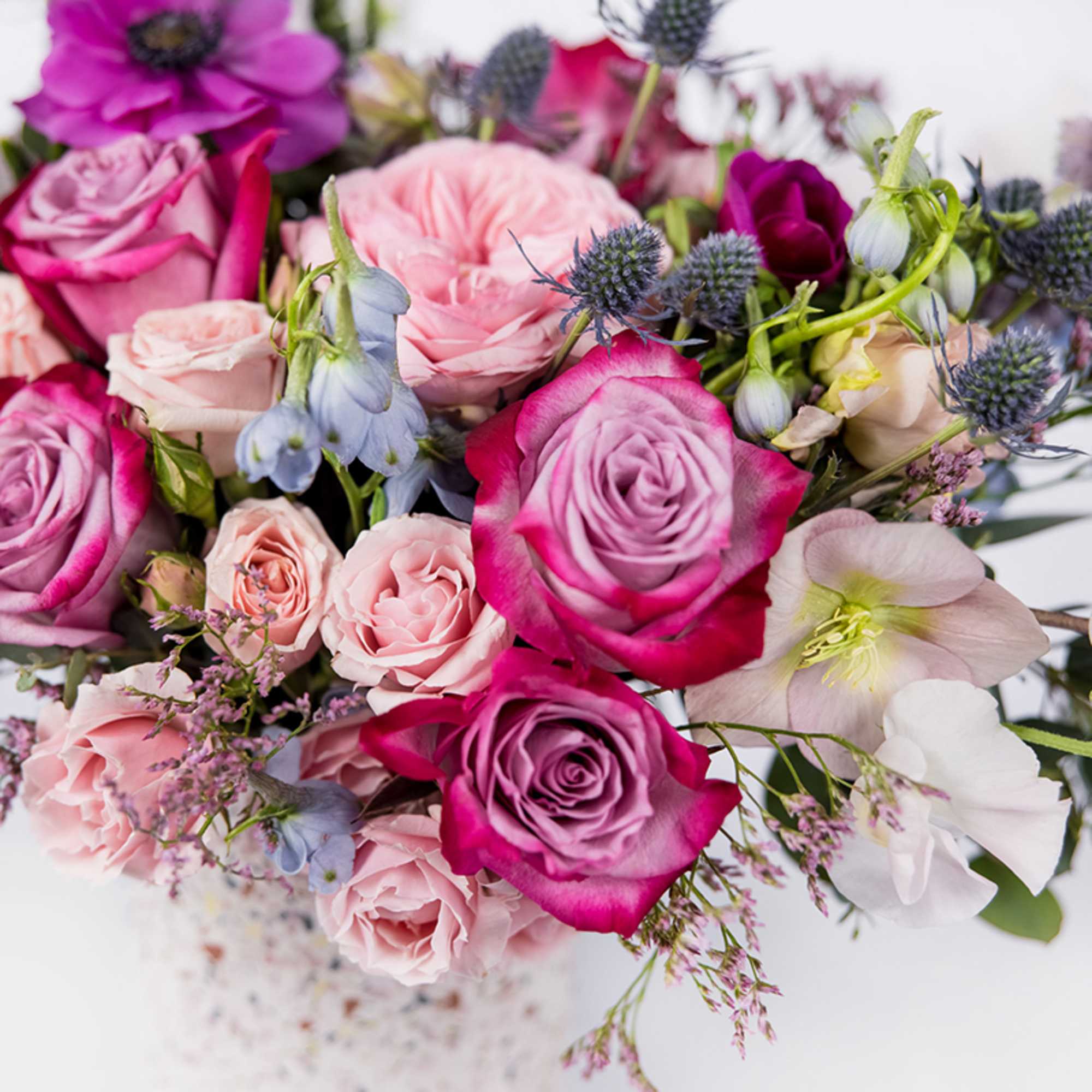 Bouquet of pink and magenta roses with pale blue flowers
