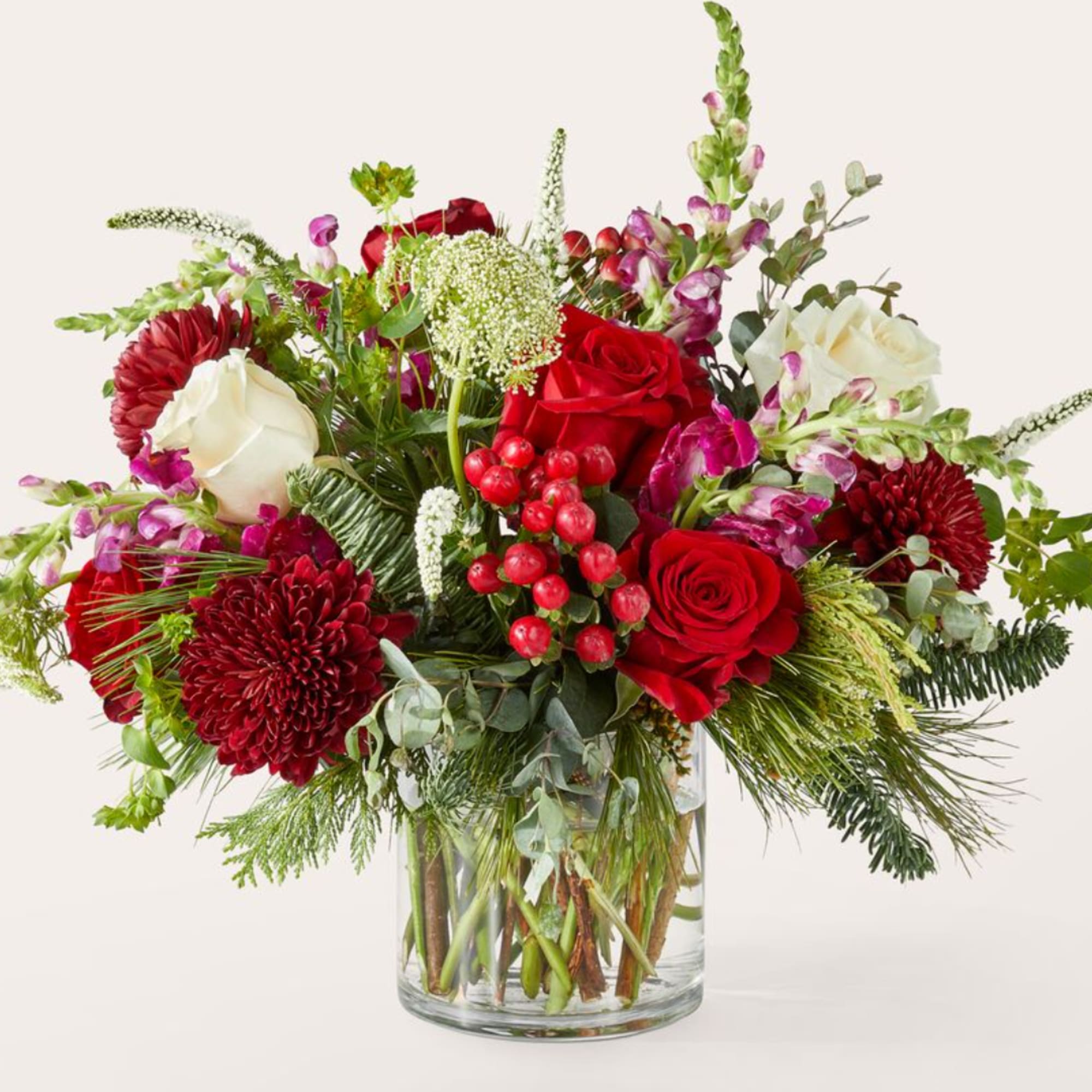 Red and white roses with burgundy mums in a glass vase