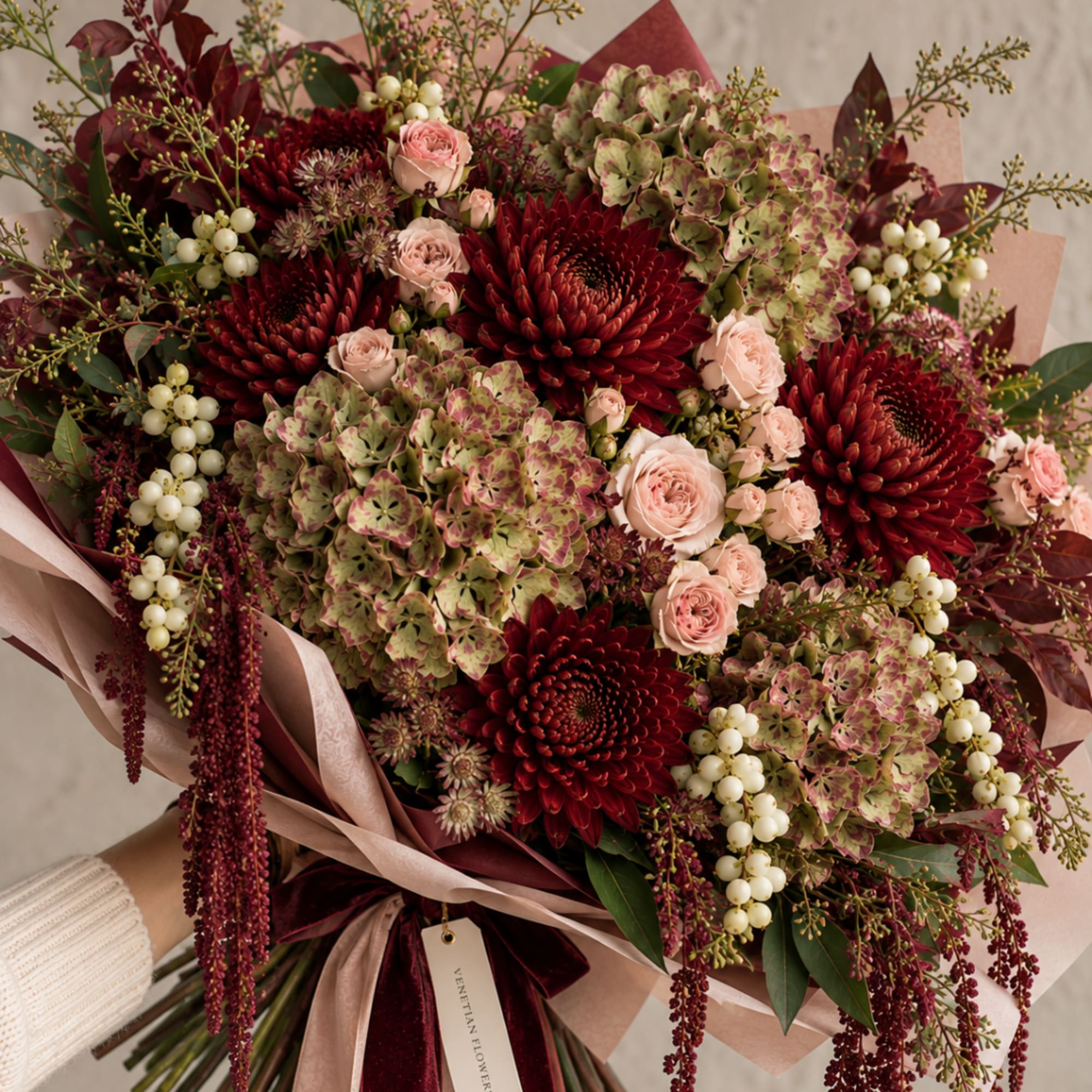 Large bouquet of burgundy and blush flowers wrapped in pink paper