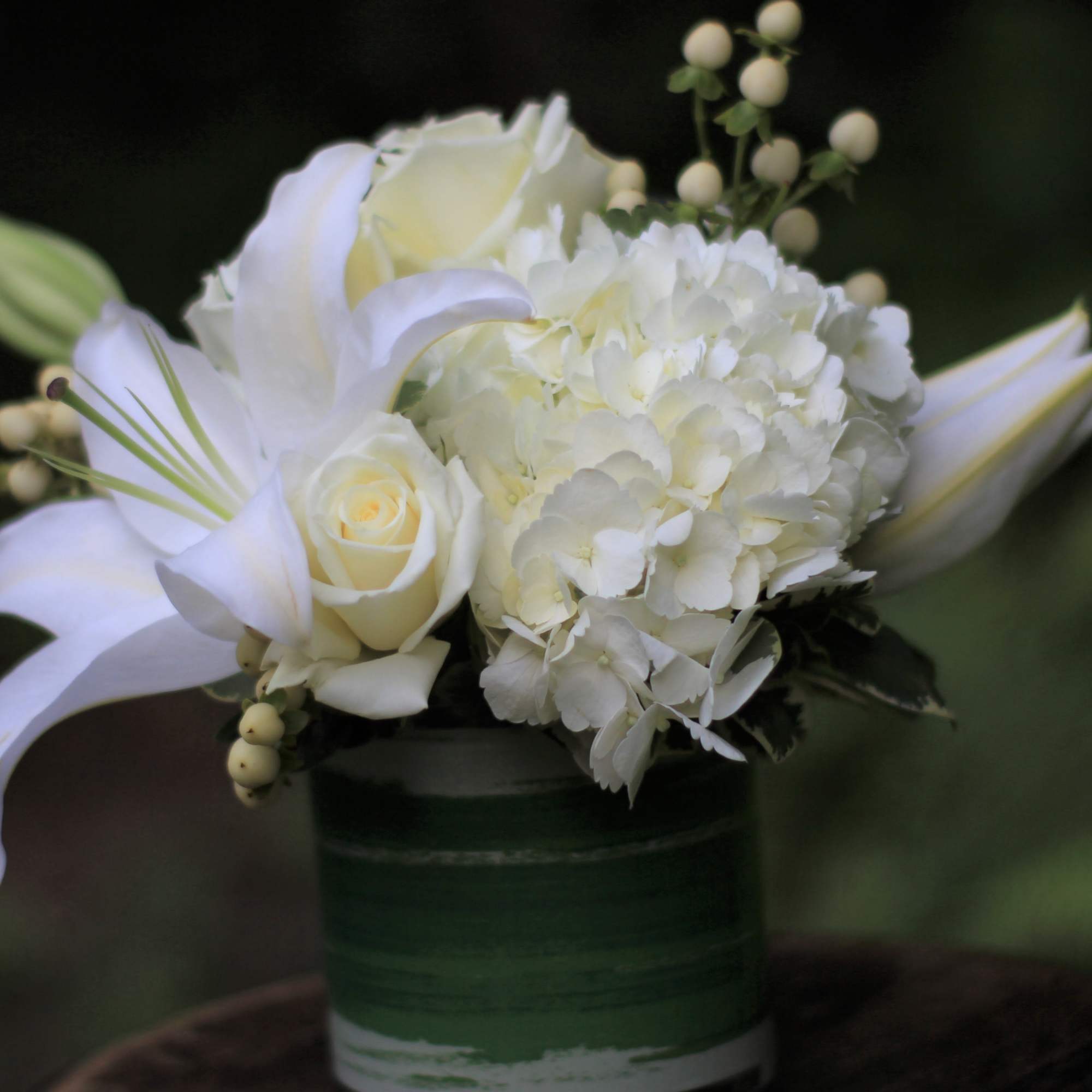 White lilies and roses in a green vase