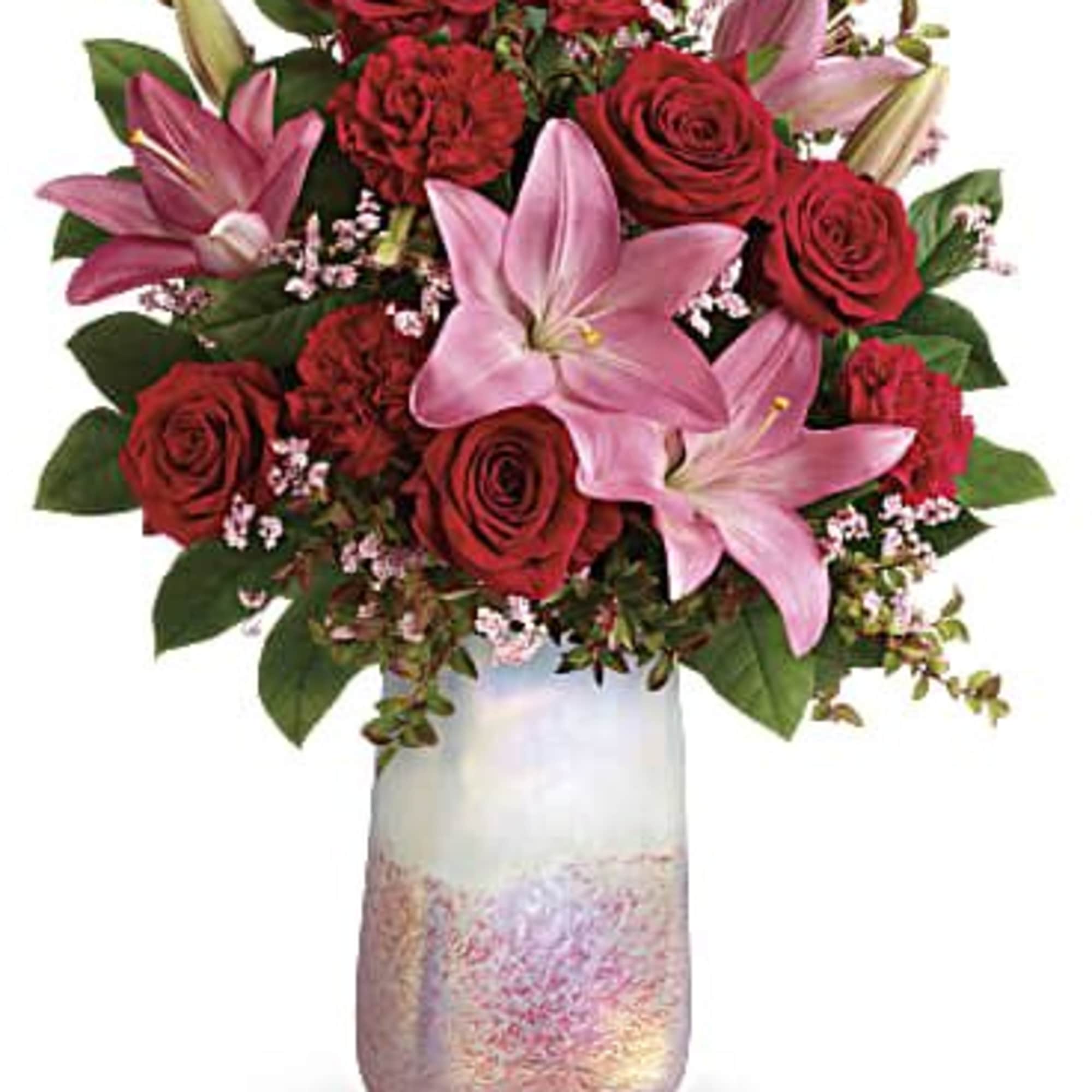 Bouquet of red roses and pink lilies in a frosted glass vase
