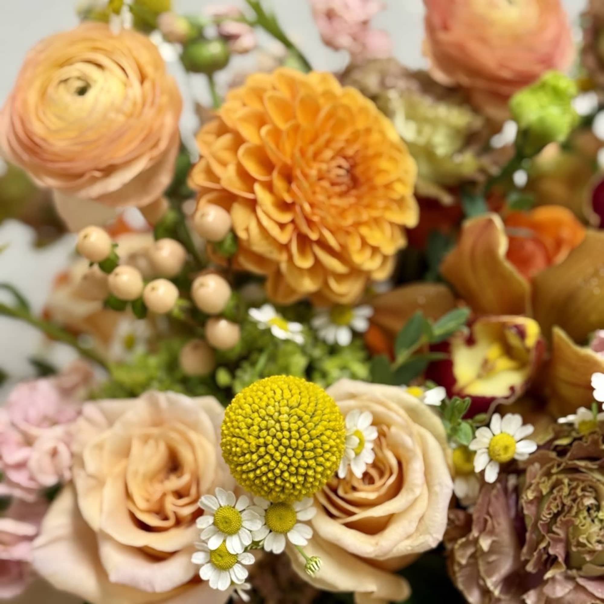 Mixed bouquet with peach roses, orange dahlias, and small white daisies