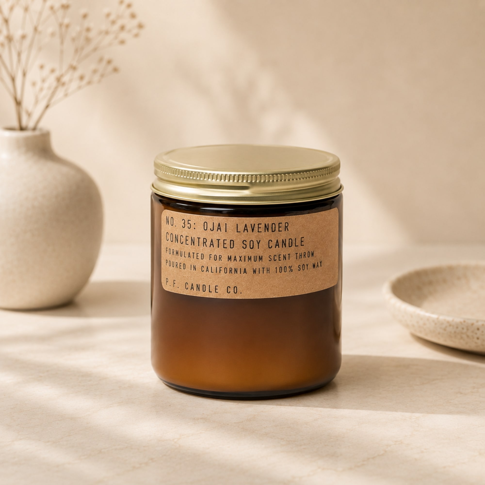 Amber jar candle with a gold lid and lavender label