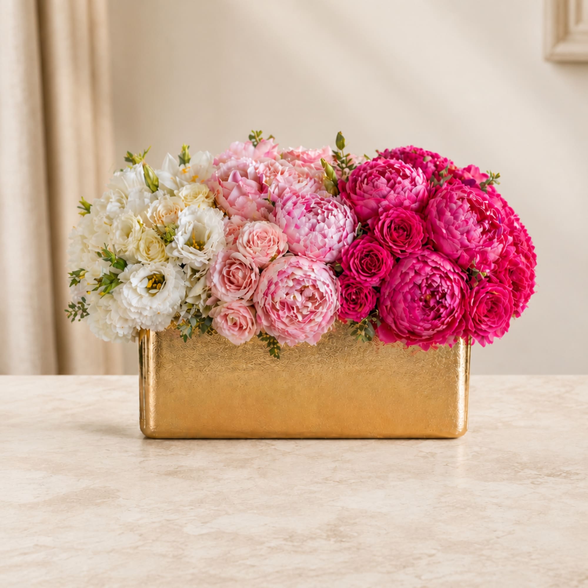 Pink, white, and magenta flowers arranged in a gold rectangular vase