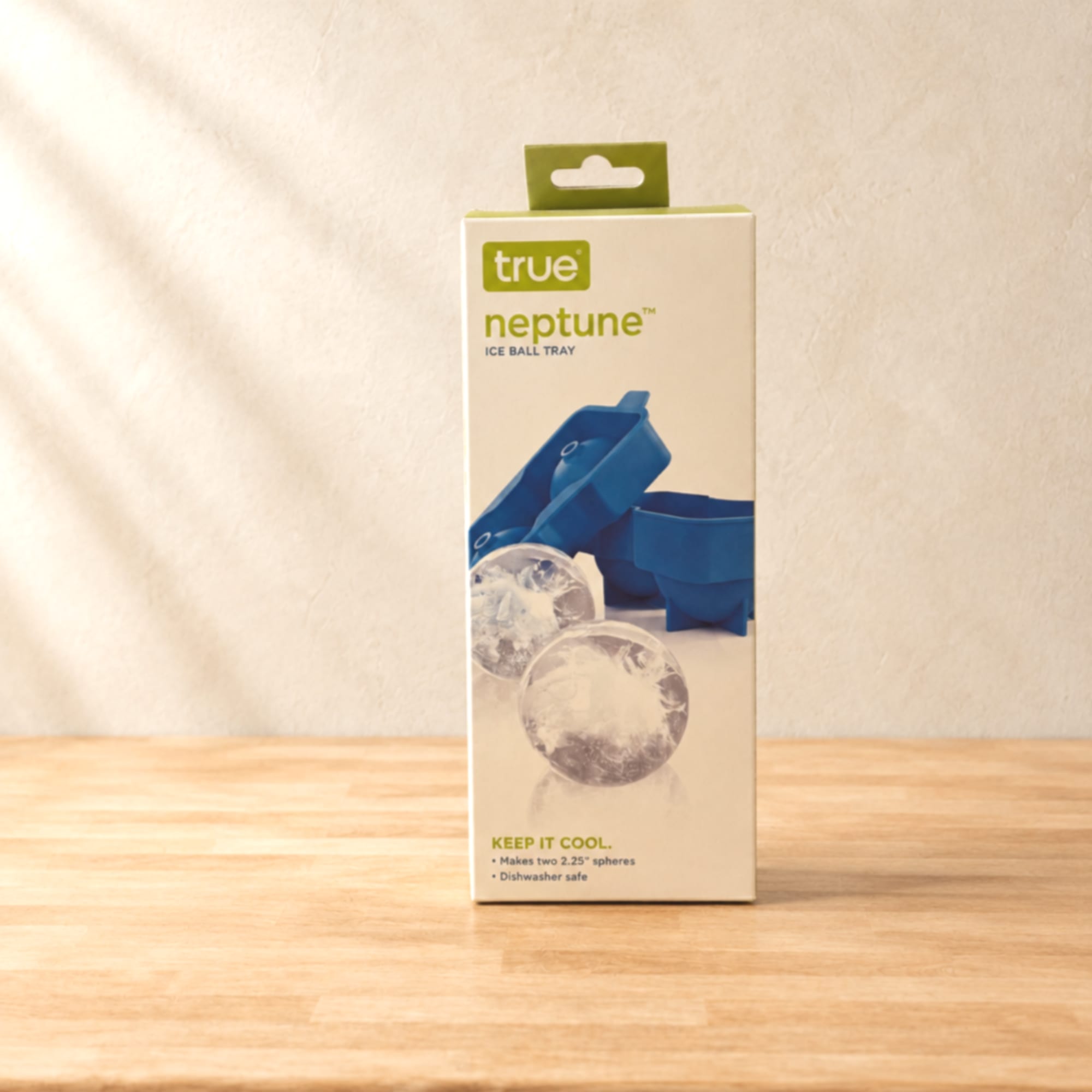 Boxed ice ball tray product standing on a wooden surface