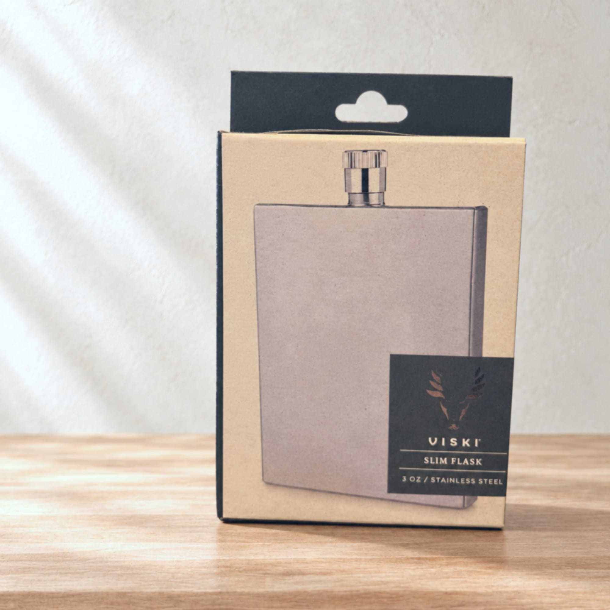 Boxed stainless steel slim flask on a wooden surface