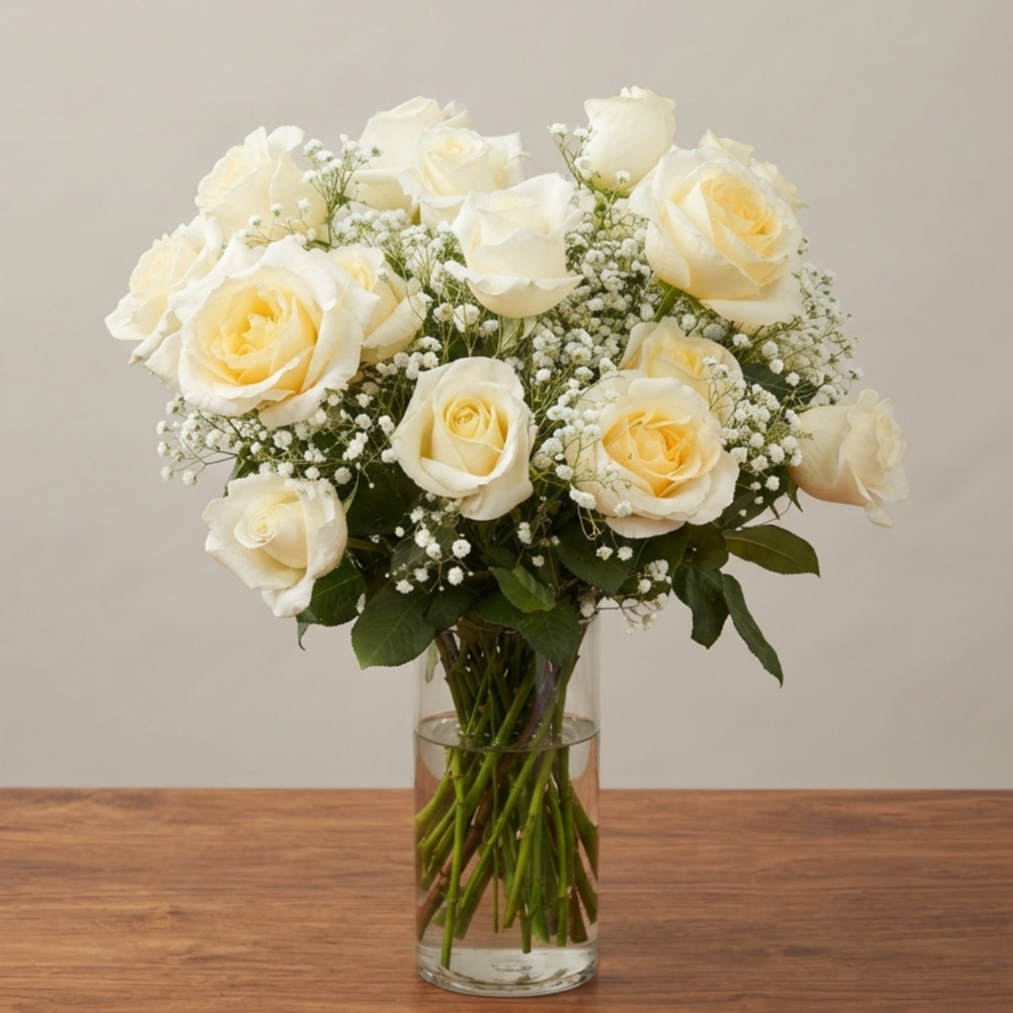 White roses and baby's breath in a clear glass vase